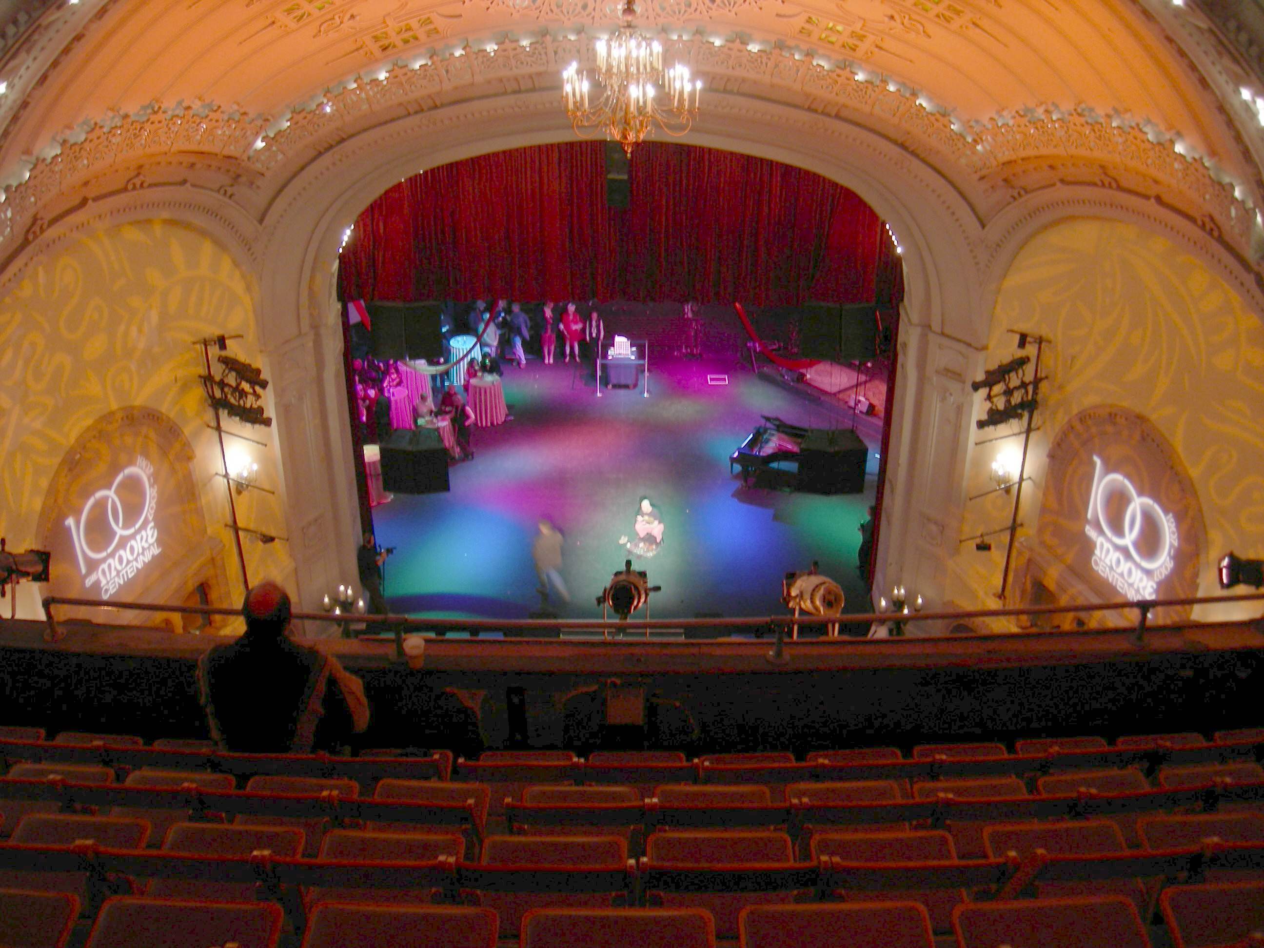 Stage of Moore Theatre, Seattle, Washington, seen from second balcony during the Moore 100 Open House Celebration, celebration of the 100th anniversary of the theater's 100th anniversary. Artis the Spoonman is setting up on the stage.