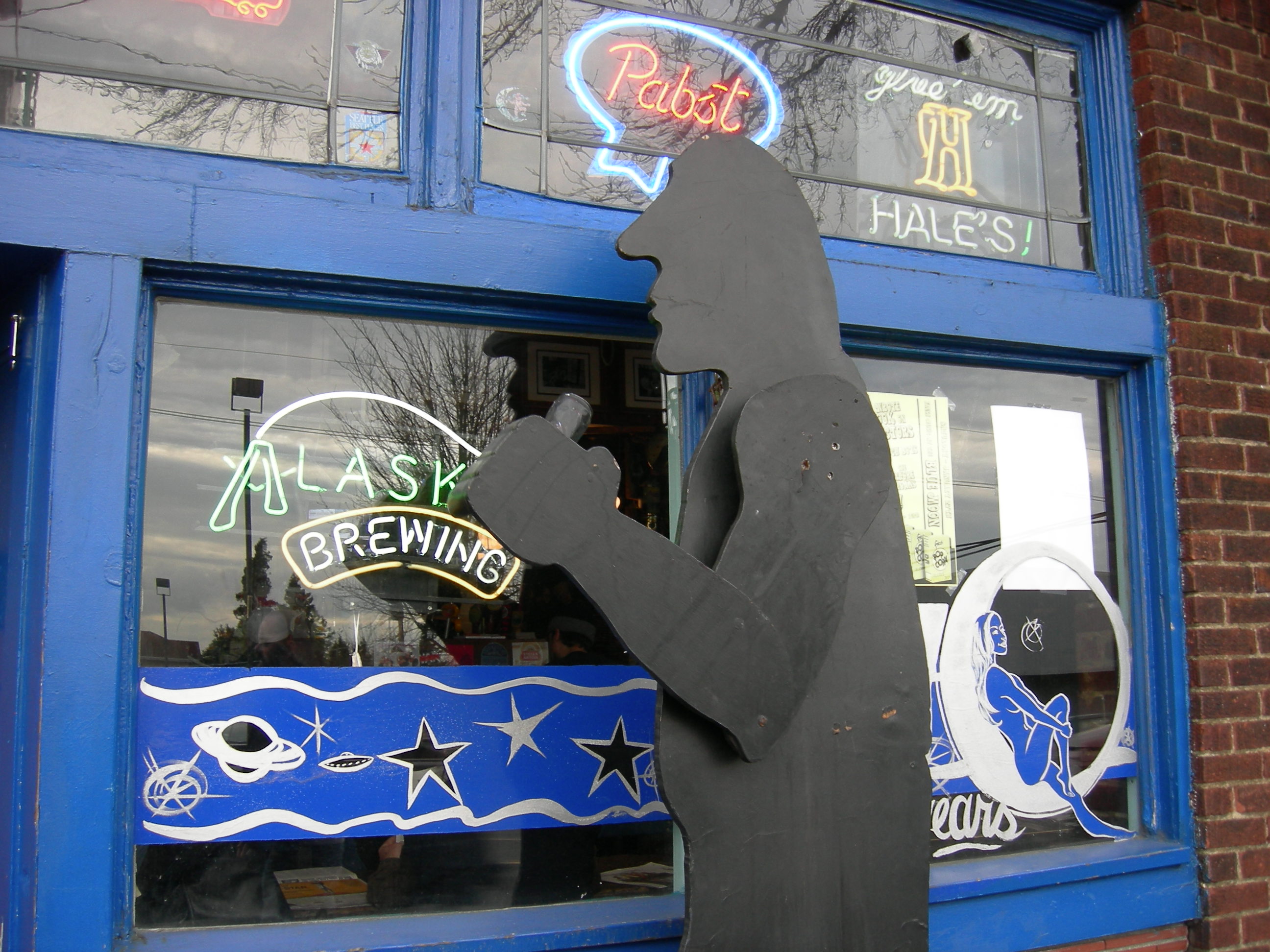 "Hammered Man", kinetic sculpture in front of the Blue Moon Tavern, University District, Seattle, Washington. The statue is placed out front in good weather, with a black-spraypainted beer can in its hand; it is a parody of the Hammering Man kinetic sculpture in front of the Seattle Art Museum and its arm operates on a similar mechanism.