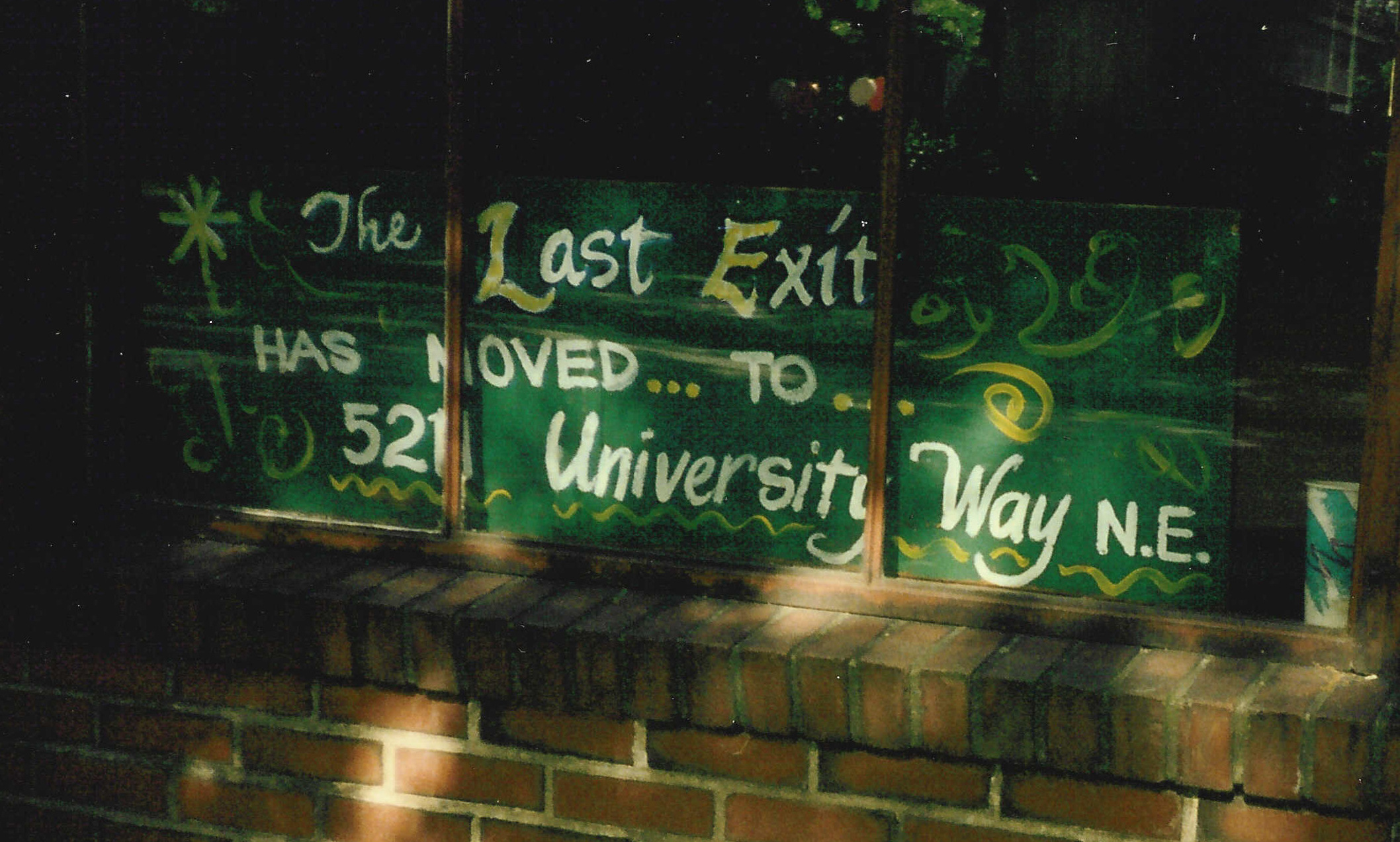 Sign indicating that the Last Exit On Brooklyn, Seattle, Washington's oldest coffeehouse at the time (now defunct), has moved. Judging by its style, the sign was probably painted by Seattle artist Eddie Walker.