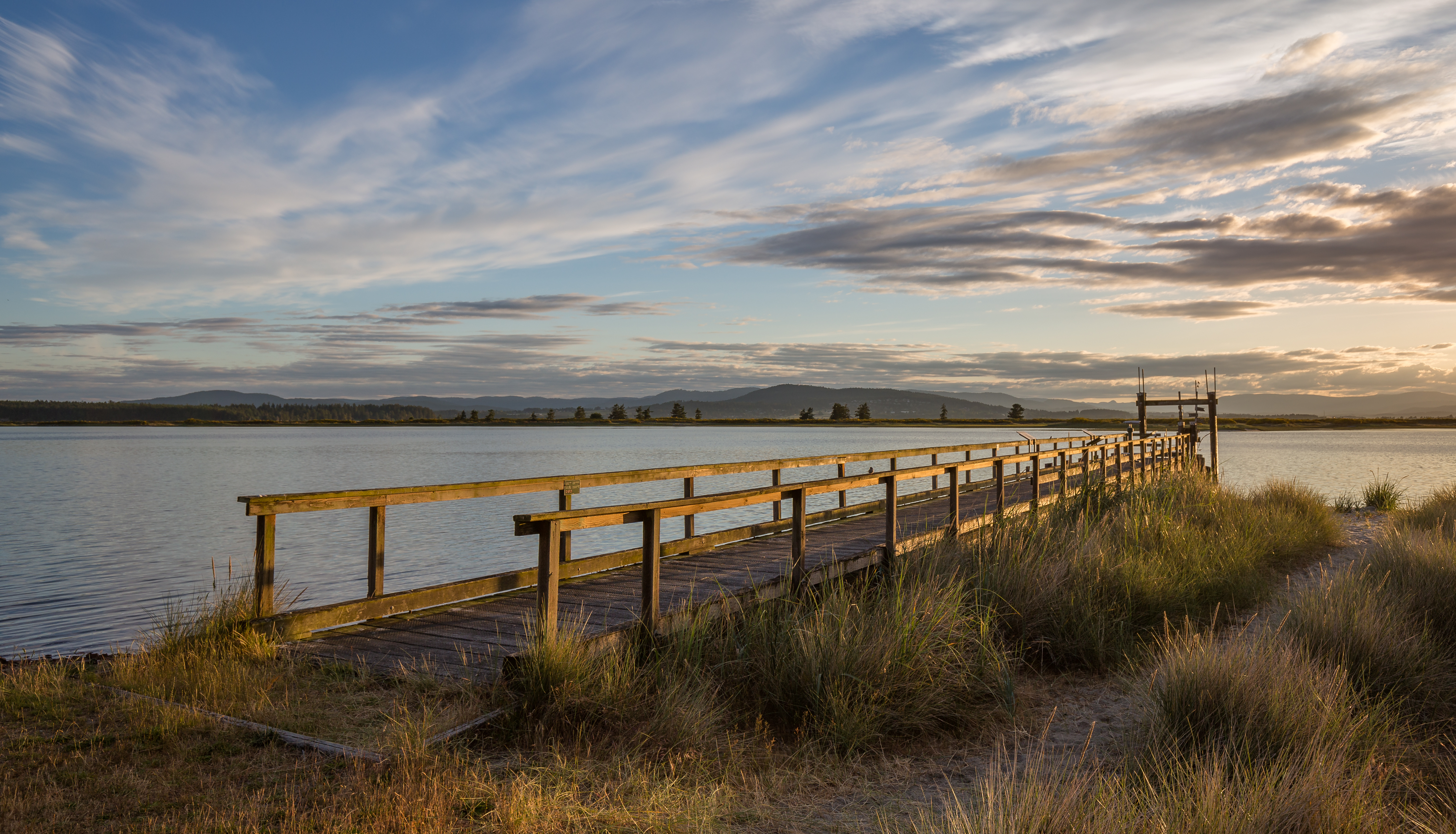A pier and a path to the beach during the sunset. Campsite at Sidney Spit (part of Gulf Islands National Park Reserve), Sidney Island, British Columbia, Canada