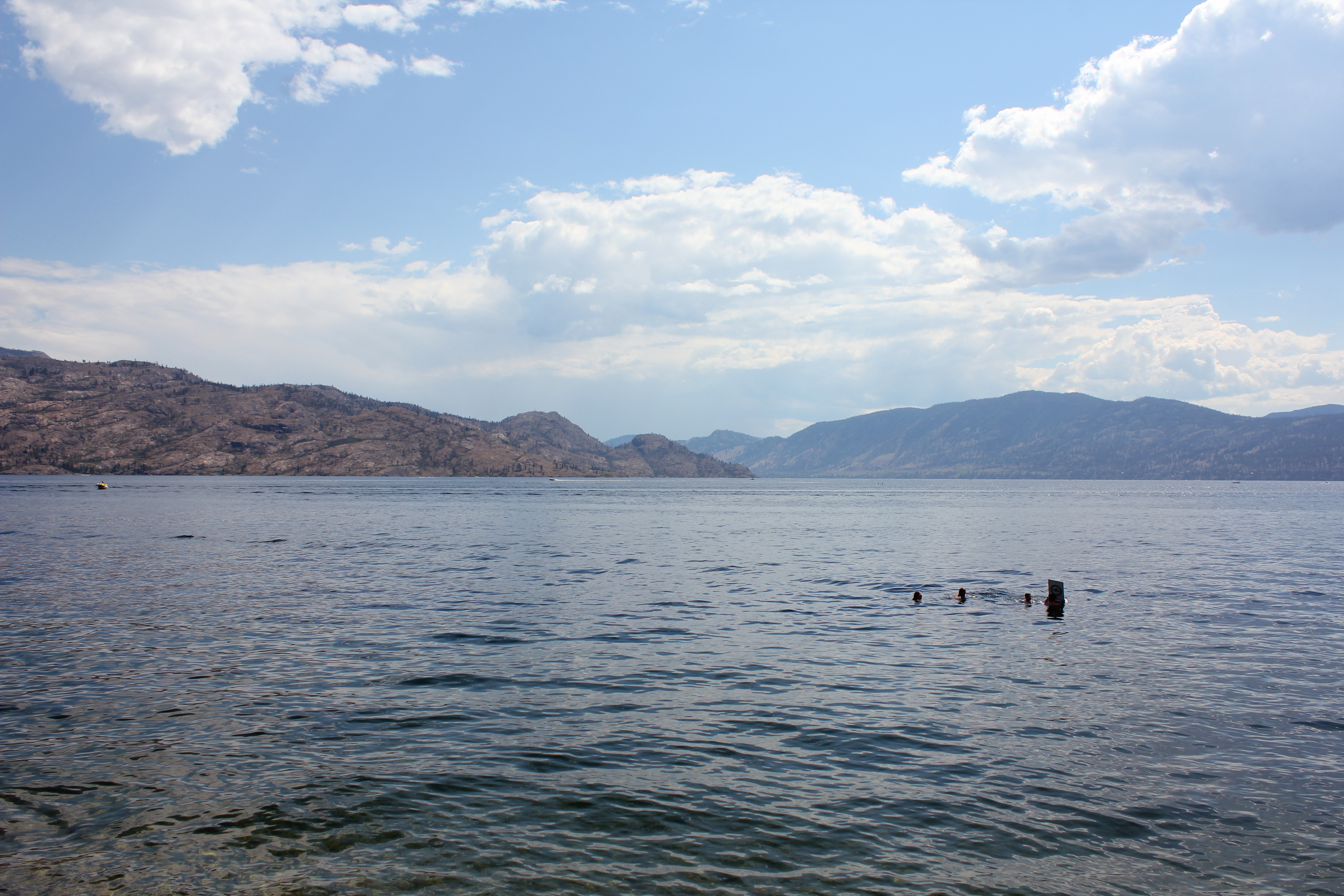 a sunny summer day people swimming in the waters of Okanagan Lake at Peachland, BC, Canada