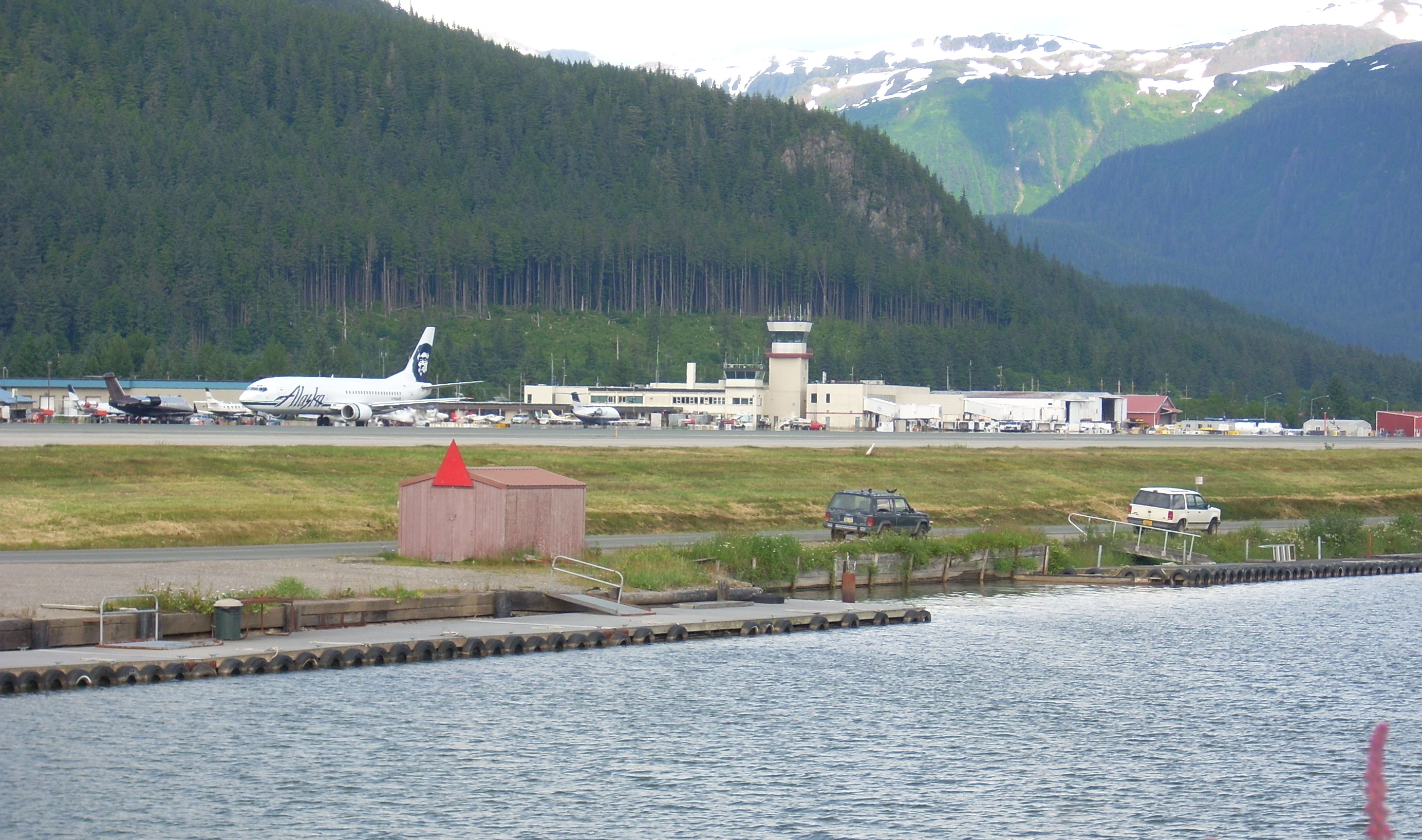 JNU with floatplane runway in foreground and a southbound Alaska airline flight preparing to taxi.