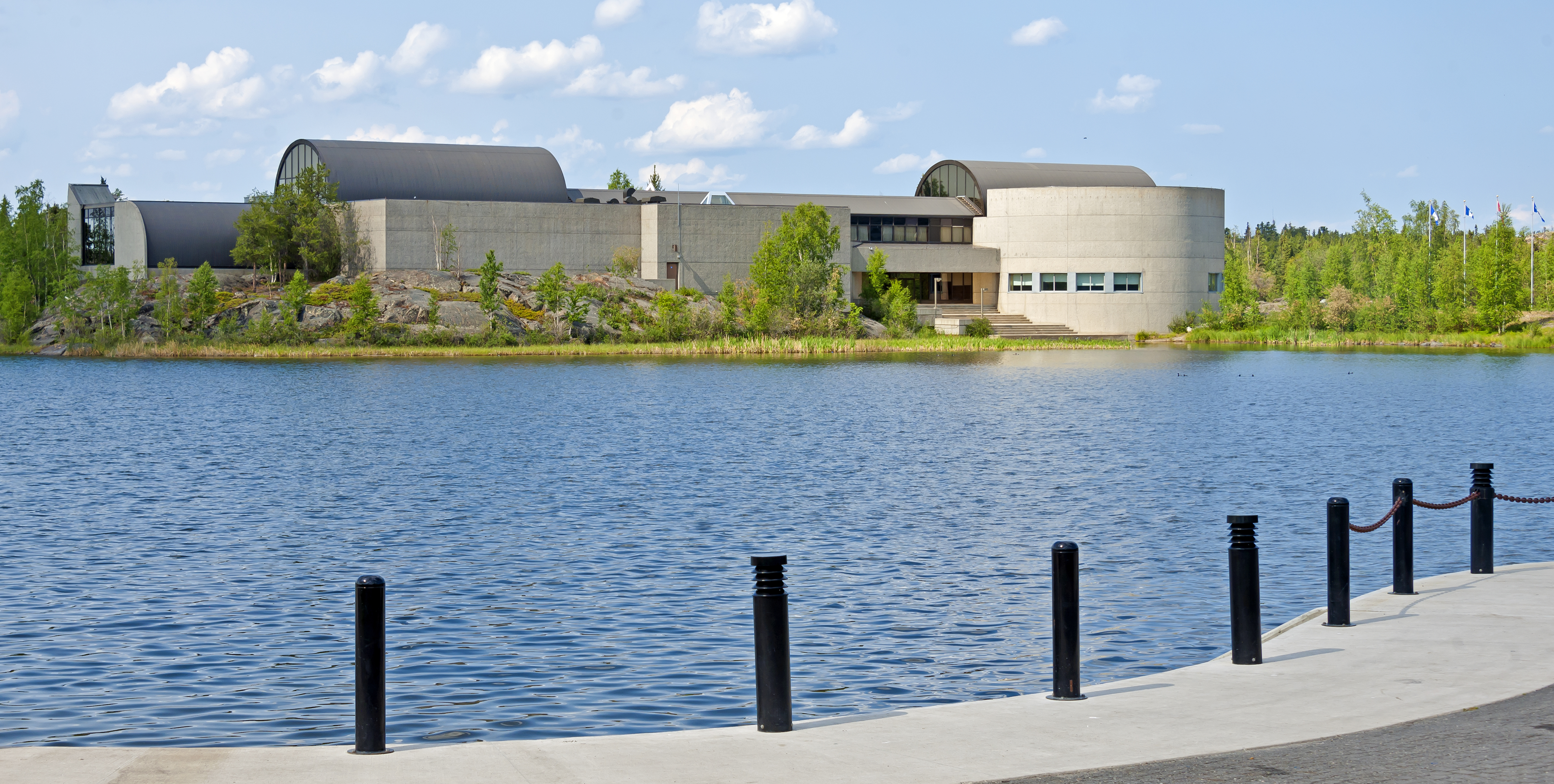 The Prince of Wales Northern Heritage Centre, Yellowknife, NT, Canada, seen from across an inlet of Frame Lake that separates it from City Hall, Fireweed Studio and the surrounding Capital Park