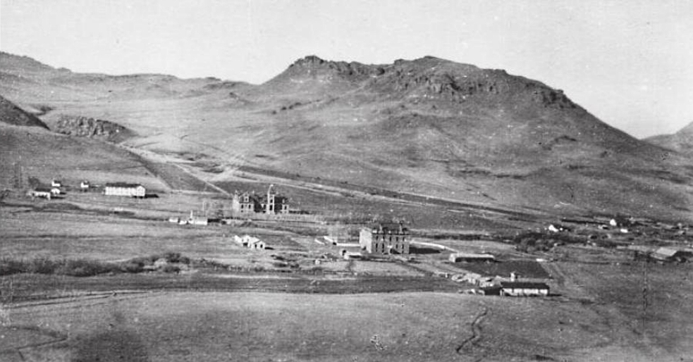 A view of St. Peter's Mission on Birch Creek (now Mission Creek) west of Cascade, Montana, in the United States.  This photograph was taken prior to 1908.
Identifiable structures include the two-story wood frame boys' school (left), the Ursuline stone convent and school (center left), the opera house (center right), and original wood frame girls' school (center right low, with tower).
Catholic Jesuit priests established St. Peter Mission in 1860 on the Sun River about 8 miles (13 km) upriver from Fort Shaw, Montana. They moved the mission 2 miles (3.2 km) downstream in 1862, but this location proved difficult for agriculture. In April 1866 the mission moved again, this time to a position 2 miles (3.2 km) south Bird Tail Rock (which is 15 miles (24 km) south of the town of Simms, Montana). The mission closed almost immediately due to hostility from a nearby Native American tribe, the Piegan Blackfeet, but reopened in 1874. The mission moved again in 1881 to Birch Creek (a point 10.5 miles (16.9 km) west-northwest of Cascade, Montana). The 1881 location is depicted here. At some point between 1874 and 1881, the Jesuits built a wood frame structure to house a school for boys.
In January 1884, the new (and founding) Bishop of the Roman Catholic Diocese of Helena, Jean-Baptiste Brondel, invited the Ursuline religious order of women to join the Jesuits at St. Peter's Mission and assist them in educating the Native Americans. Five Ursuline sisters arrived in October 1884. In 1885, they built several log cabins and a wood frame structure that contained a chapel and classrooms for girls. This structure also had a two-and-a-half story bell tower. The Ursulines built a three-story stone building with basement beginning in 1892, into which the girls' school moved in 1896. This structure was funded by donations from the future Saint, Katharine Drexel, a Philadelphia, Pennsylvania, heiress. This building also served as the nuns' convent. Over time, the Jesuits and Ursulines built a bakery, barn, corral, laundry, and workers' housing. The Ursulines—who believed in music and art training as well as education in reading, math, and science—also built an opera house at St. Peter's in 1896. The Jesuits stopped educating boys, turning that function over to the nuns.
The boys' school closed in 1896, and fire destroyed it in 1908. The Ursulines moved their school into nearby Great Falls, Montana, in 1912. Fire destroyed the stone convent/school and the girls' wood frame school in 1918. St. Peter's was largely abandoned afterward.

The ruins of St. Peter's Mission remained a popular tourist spot for many decades. As of 2010, only the foundations of a few structures remained at St. Peter's.