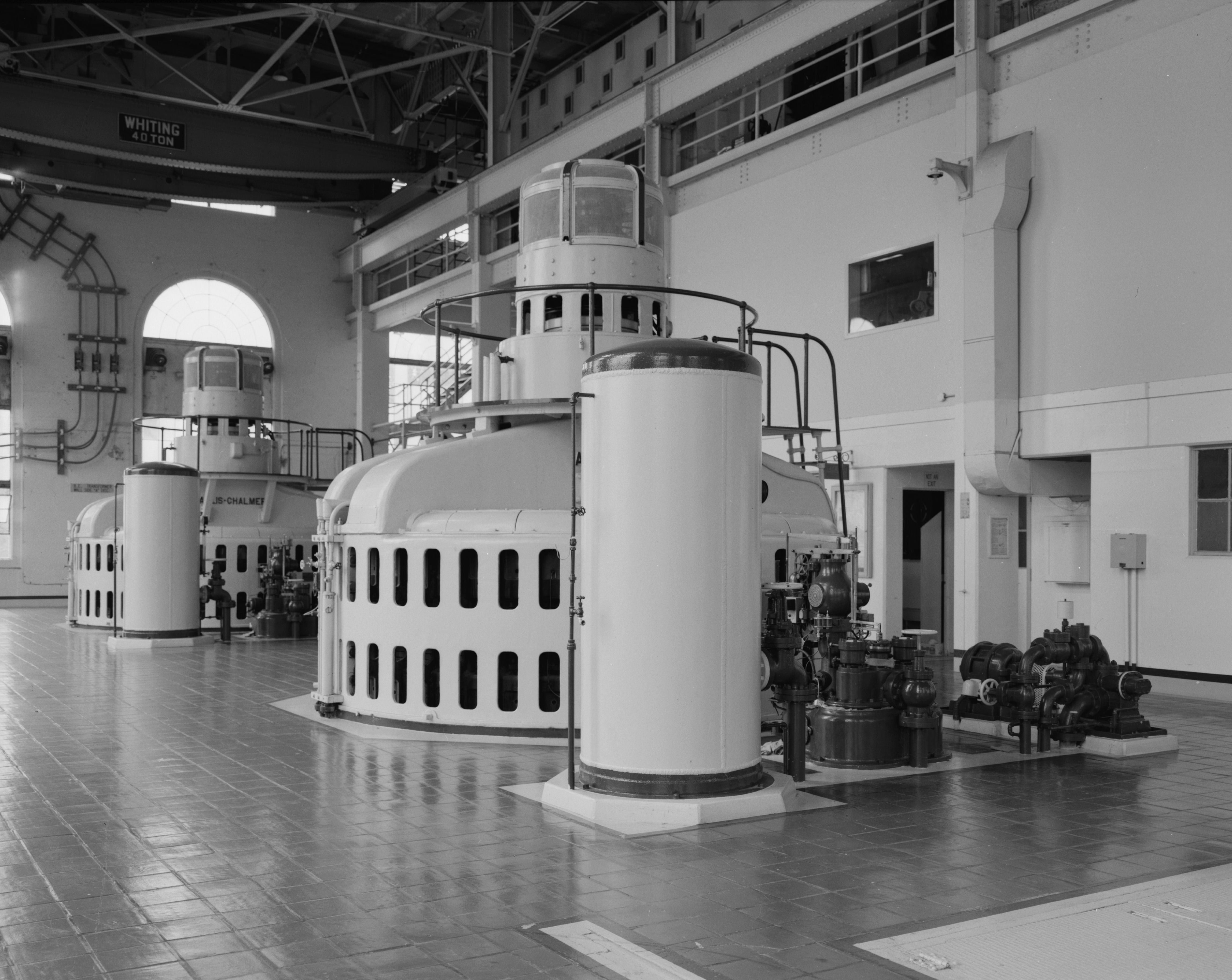 Interior of the powerhouse of the Black Eagle Dam on the Missouri River in Great Falls, Montana, United States, in 1996.  Turbine No. 2 is in the foreground; Turbine No. 3 is in the rearground. In front of each turbine (left to right) are the oil tank for the oil-pressure governor, the governor stand, and the oil pump.