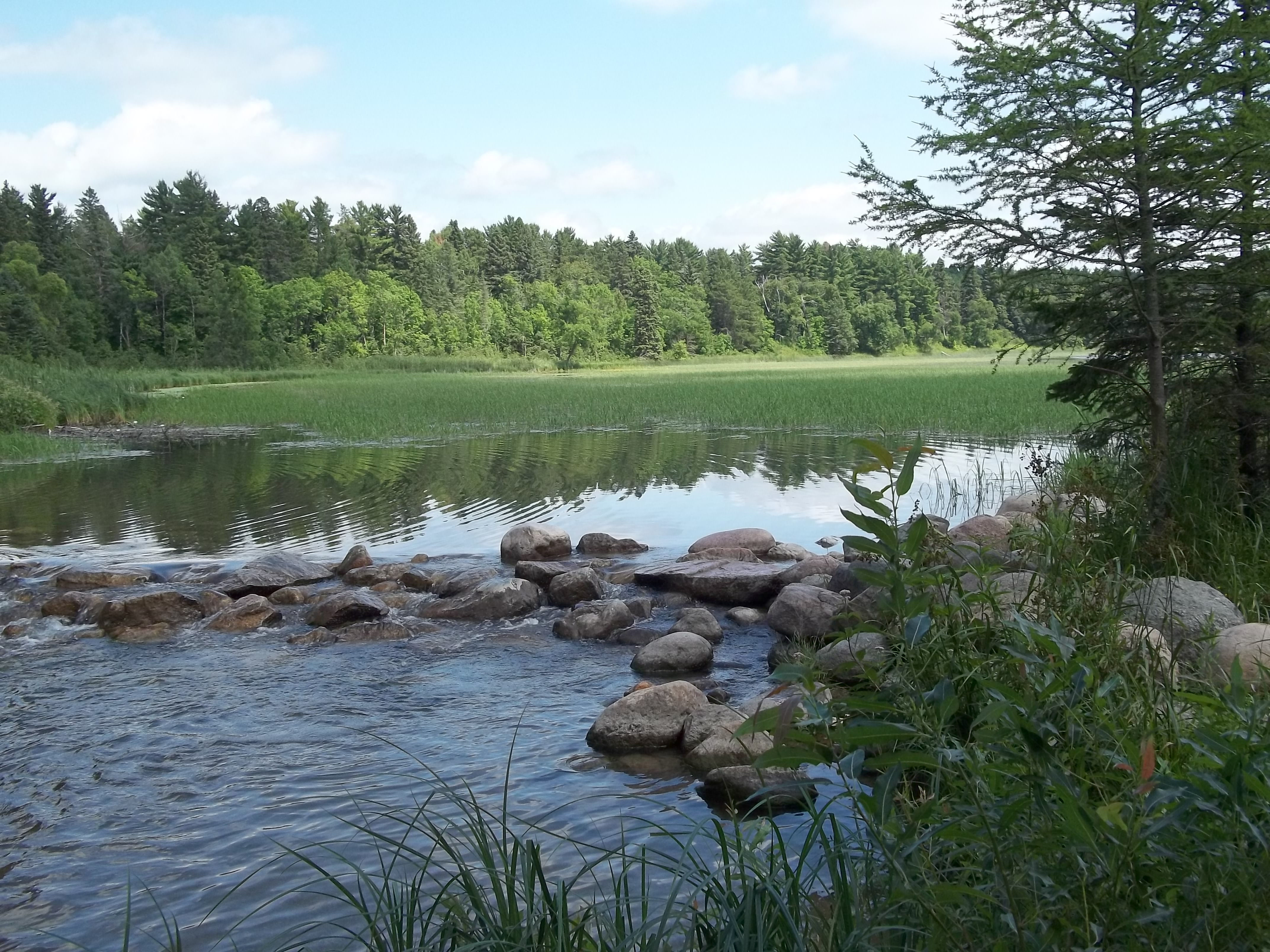 Headwaters of the Mississippi River. Above the rocks is the north end of Minnesota's Lake Itasca, which begins the flow of the Mississippi River to its eventual end point in the Gulf of Mexico.