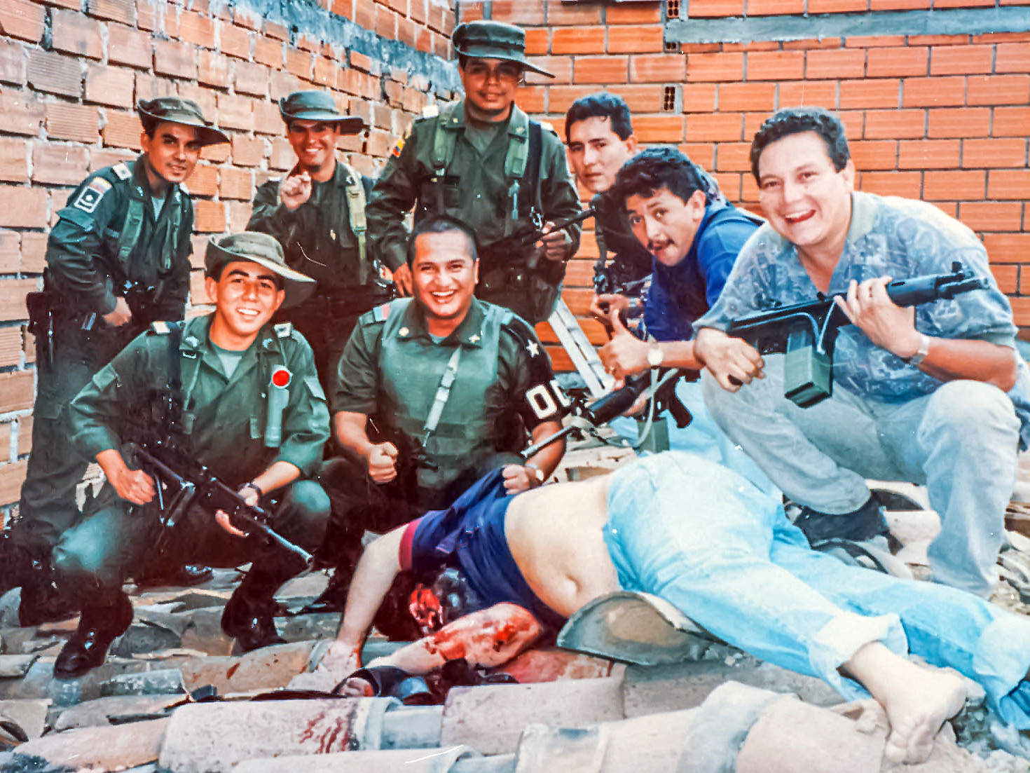 Members of Colonel Martinez's Search Bloc celebrate over Pablo Escobar's body on December 2, 1993. Pablo's death ended a fifteen-month effort that cost hundreds of millions of dollars.