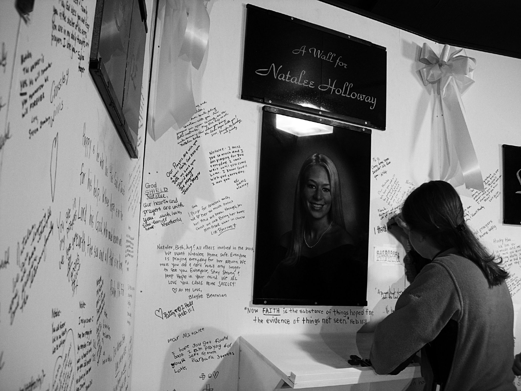 Young female signing a memorial wall for Natalee Holloway, less than two weeks after her disappearance.