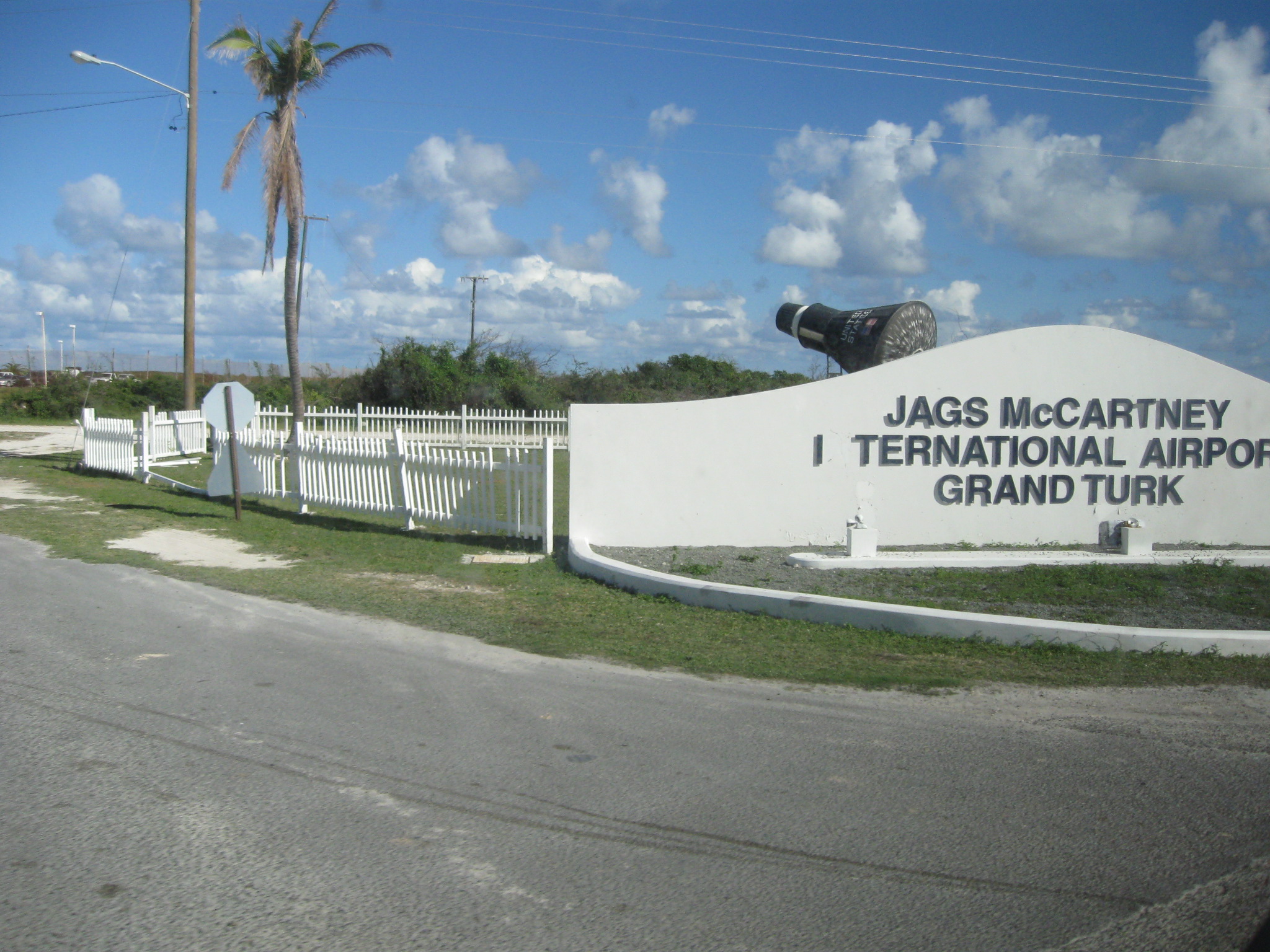 I took this picture from a moving taxi on Grand Turk in the Turks and Caicos. Note: Mercury capsule replica; apparent hurricane damage| to fence and sign. There are numerous instances of hurricane damage still on the island, as of three/four months after the hurricanes (Hurricane Hanna being the other one, besides Ike).