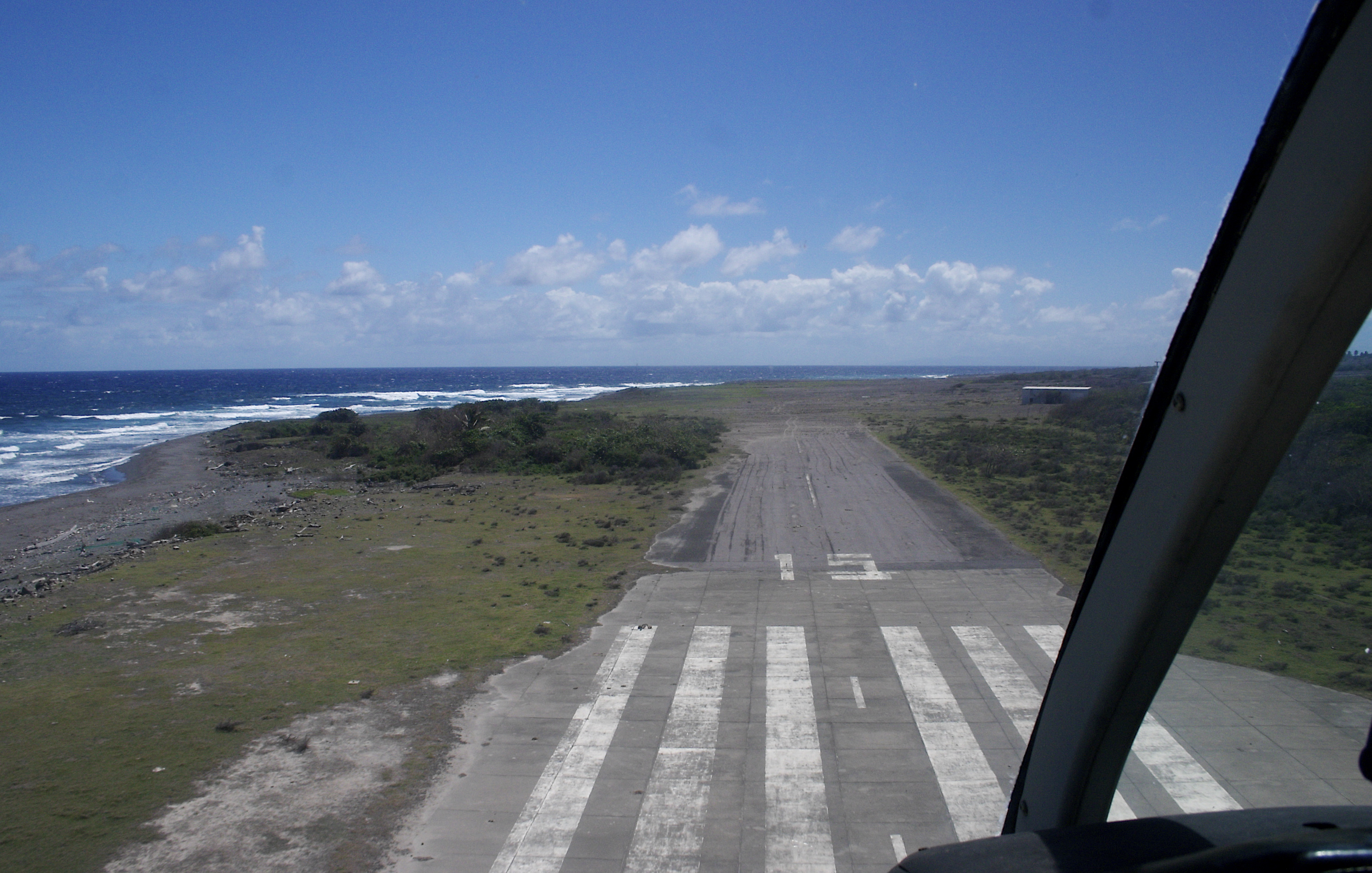 The remains of runway 15 of the abandoned W.H. Bramble International Airport, Montserrat, as seen from helicopter.