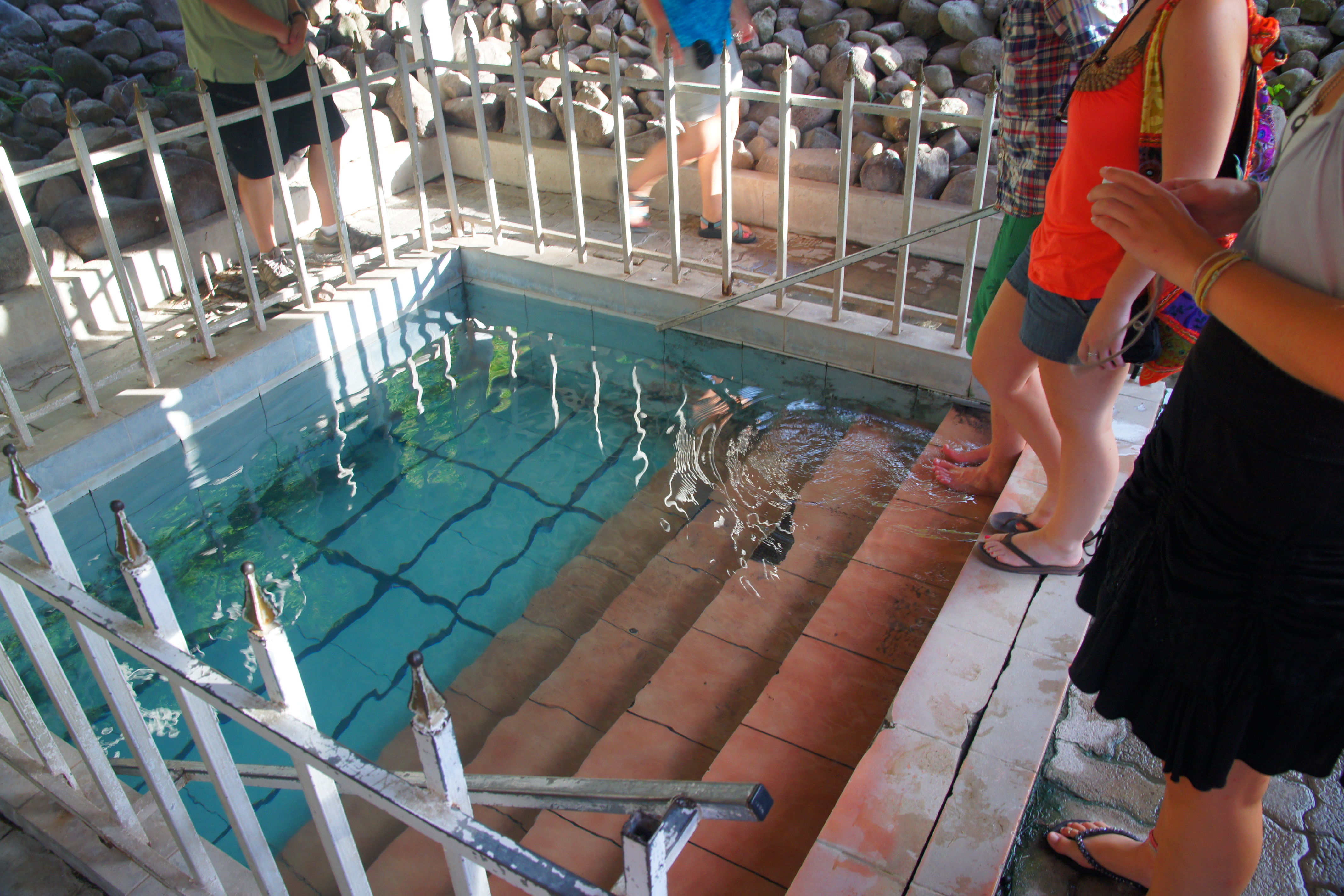 Pool of hot water on the island of Nevis resulting from geothermal activity. The island is a member of the country St. Kitts and Nevis in the Lesser Antilles. The pool pictured is neighbored by hot spring water flowing naturally in a dirt depression.
A sign above the pool reads:
"Relaxing Pool - Use at your own risk, always be accompanied, do not use if you have a heart problem, maximum time recommended 15 min., not for children 12 yrs and under, soap must not be used - This pool was made possible with the kind contributions of E.J.E (Nevis), Margaret Huggins Burrall, Emile Newton (Golden Rock), Super Foods Supermarket, Nevis Island Government"