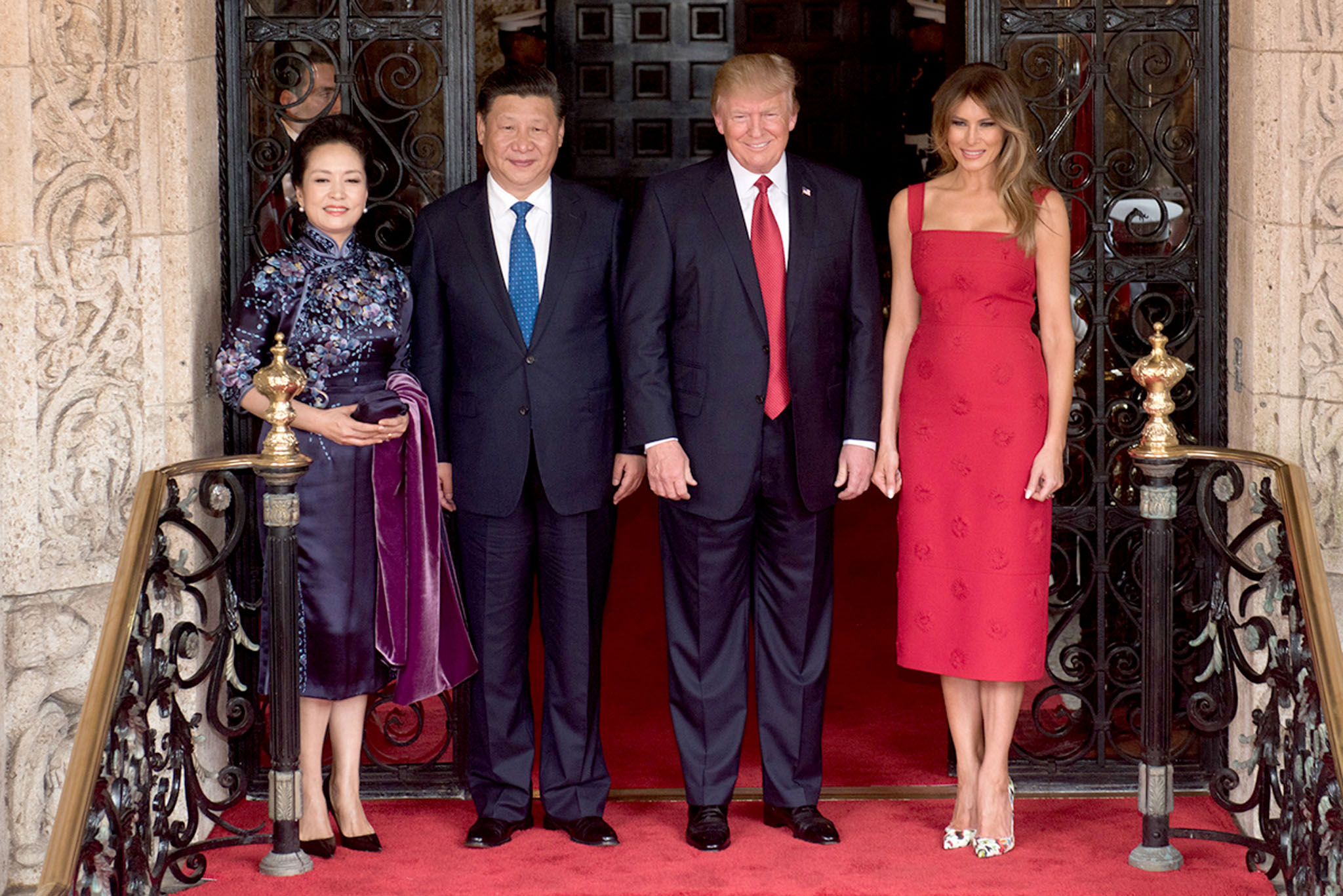 US President Donald Trump and First Lady Melania Trump pose for a photo with General Secretary of the Chinese Communist Party Xi Jinping and his wife, Mrs. Peng Liyuan, Thursday, April 6, 2017, at the entrance of Mar-a-Lago in Palm Beach, FL (Official White Photo by D. Myles Cullen). Melania Trump stepped out in a red, wide-strap Valentino midi dress with daisy appliqués[1]
