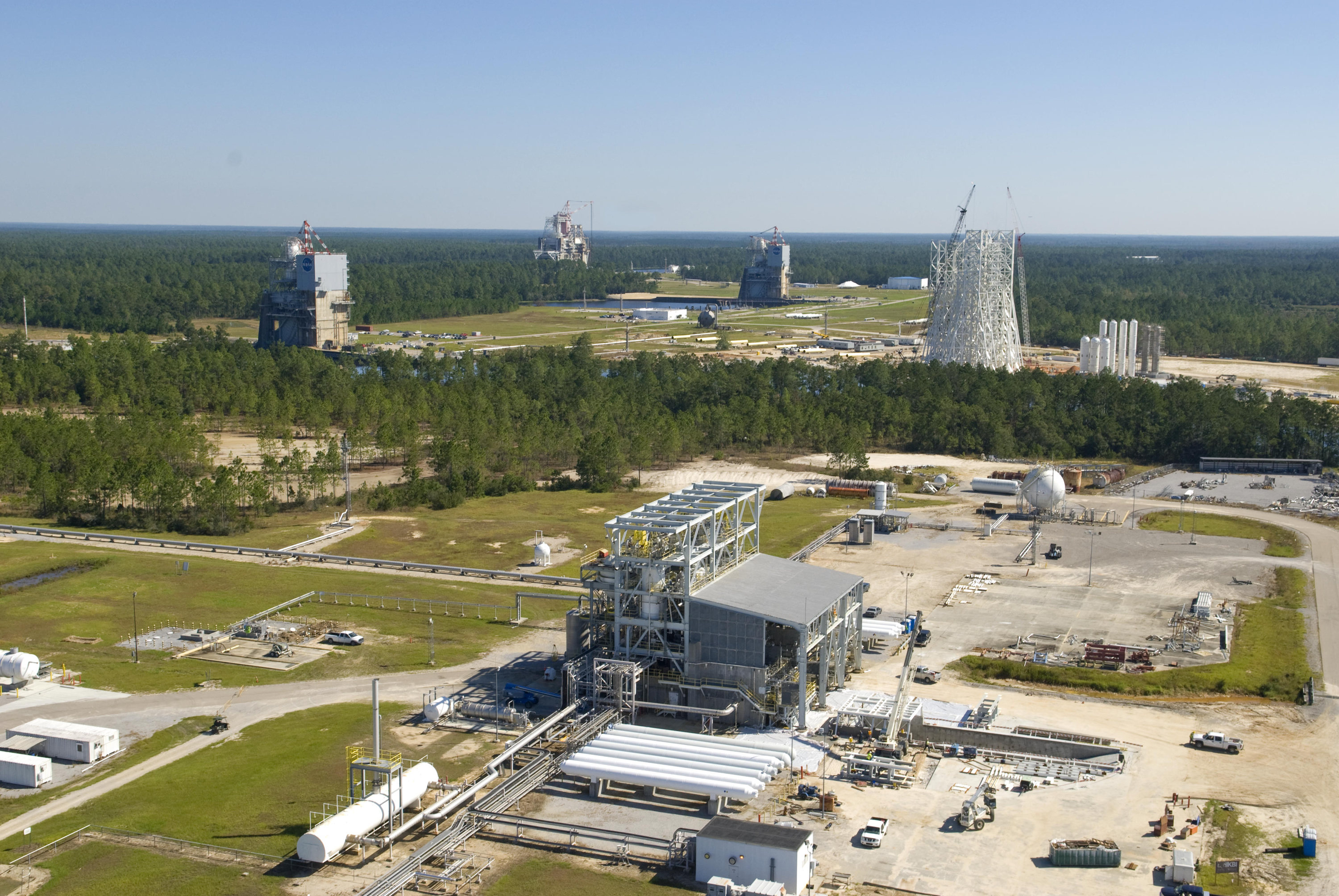 An aerial photo shows all three NASA Stennis Space Center (SSC) test complexes - the E Test Complex (foreground), the three A Test Complex stands (middle) and the B Test Complex (back). The versatility of the stands and the four decades of testing history make Stennis the premier rocket engine test facility in the nation.