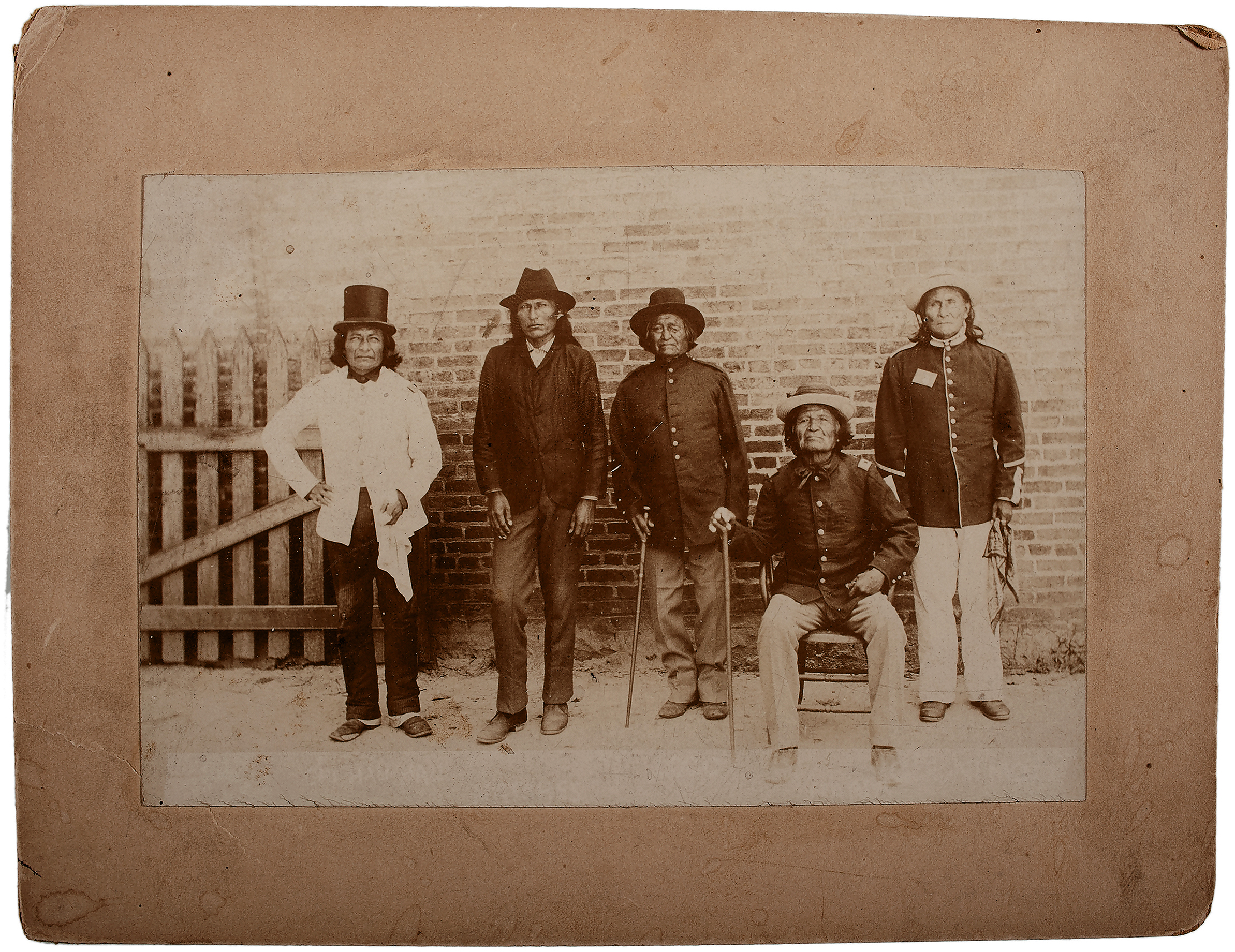 Silver gelatin photograph, 6.5 x 4.25 in., on 6.5 x 8.5 in. mount, capturing Apache prisoners of war at Mount Vernon Barracks, AL, ca 1887-1894, namely (left to right): Chief Chihuahua, Chief Naiche, Chief Loco, Chief Nana, and Chief Geronimo. From 1887-1894, Mt. Vernon Barracks, AL served as home to imprisoned Apaches, including Geronimo and a number of his band members before they were transferred to Fort Sill, OK.