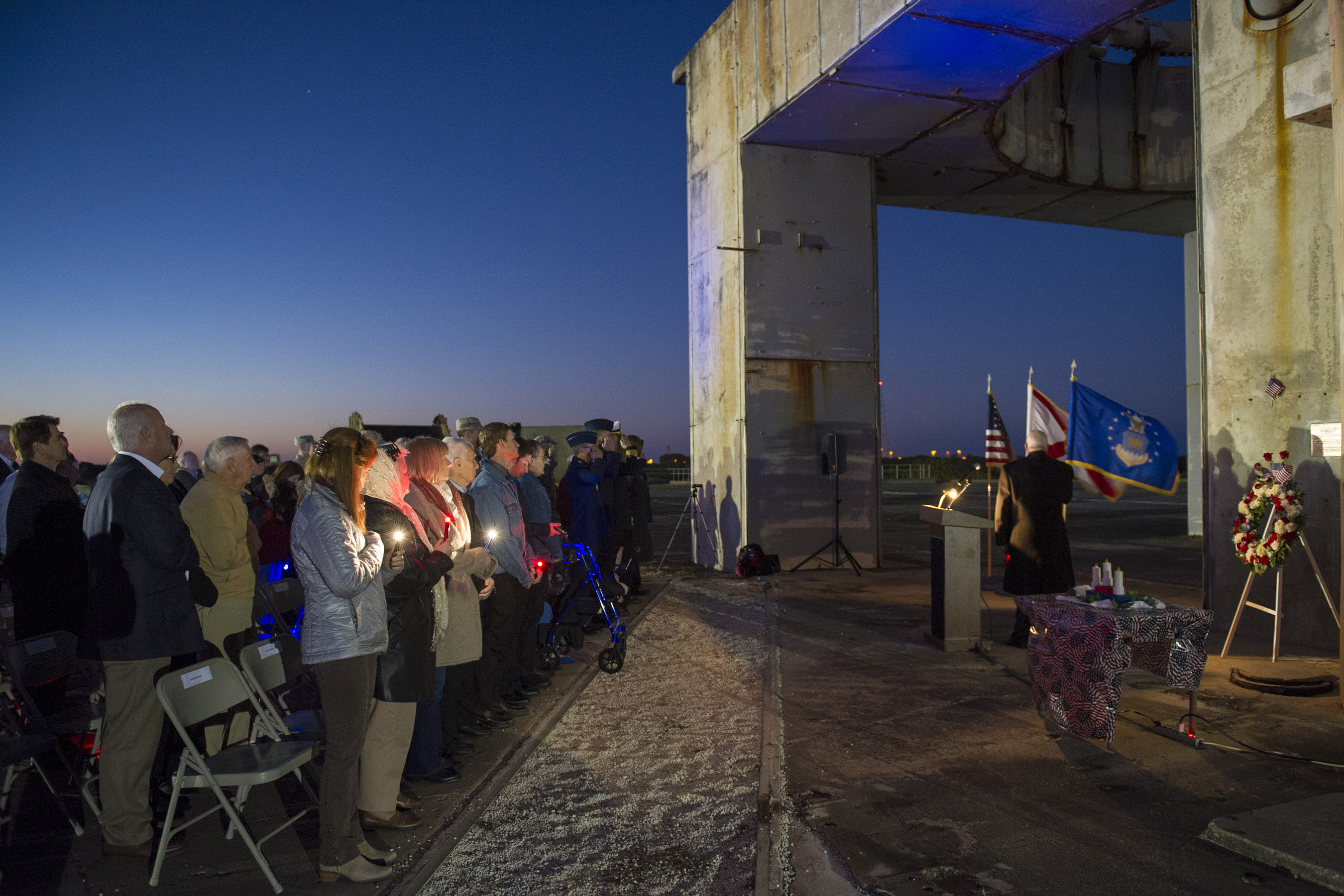 Members of an audience honor three former space pioneers at the 48th annual Apollo 1 Memorial Ceremony Jan. 27, 2015, at Cape Canaveral Air Force Station, Fla. The ceremony honored the lives of the three crew members, Command Pilot Virgil "Gus" Grissom, Senior Pilot Edward H. White II and Pilot Roger B. Chaffee, who were killed by a flash fire during a launch pad test of their Saturn 1B rocket, Jan. 27, 1967.  (U.S. Air Force photo by Matthew Jurgens/Released)