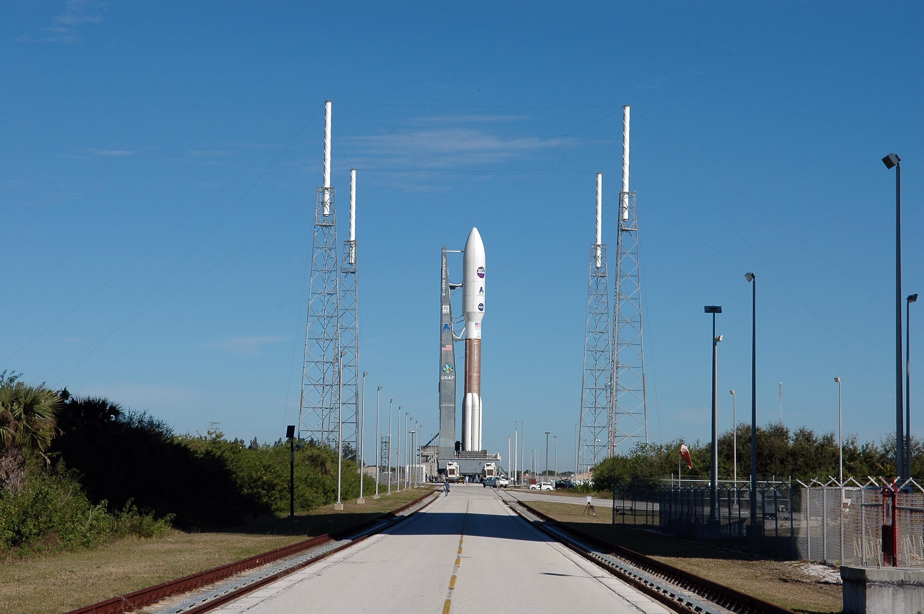 On Complex 41 at Cape Canaveral Air Force Station, the Atlas V expendable launch vehicle with the New Horizons spacecraft has been moved to the pad. Umbilicals have been attached. Seen near the rocket are lightning masts that support the catenary wire used to provide lightning protection. Liftoff is scheduled for 1:24 p.m. EST Jan. 17. After its launch aboard the Atlas V, the compact, 1,050-pound piano-sized probe will get a boost from a kick-stage solid propellant motor for its journey to Pluto. New Horizons will be the fastest spacecraft ever launched, reaching lunar orbit distance in just nine hours and passing Jupiter 13 months later. The New Horizons science payload, developed under direction of Southwest Research Institute, includes imaging infrared and ultraviolet spectrometers, a multi-color camera, a long-range telescopic camera, two particle spectrometers, a space-dust detector and a radio science experiment. The dust counter was designed and built by students at the University of Colorado, Boulder. A launch before Feb. 3 allows New Horizons to fly past Jupiter in early 2007 and use the planet’s gravity as a slingshot toward Pluto. The Jupiter flyby trims the trip to Pluto by as many as five years and provides opportunities to test the spacecraft’s instruments and flyby capabilities on the Jupiter system. New Horizons could reach the Pluto system as early as mid-2015, conducting a five-month-long study possible only from the close-up vantage of a spacecraft.