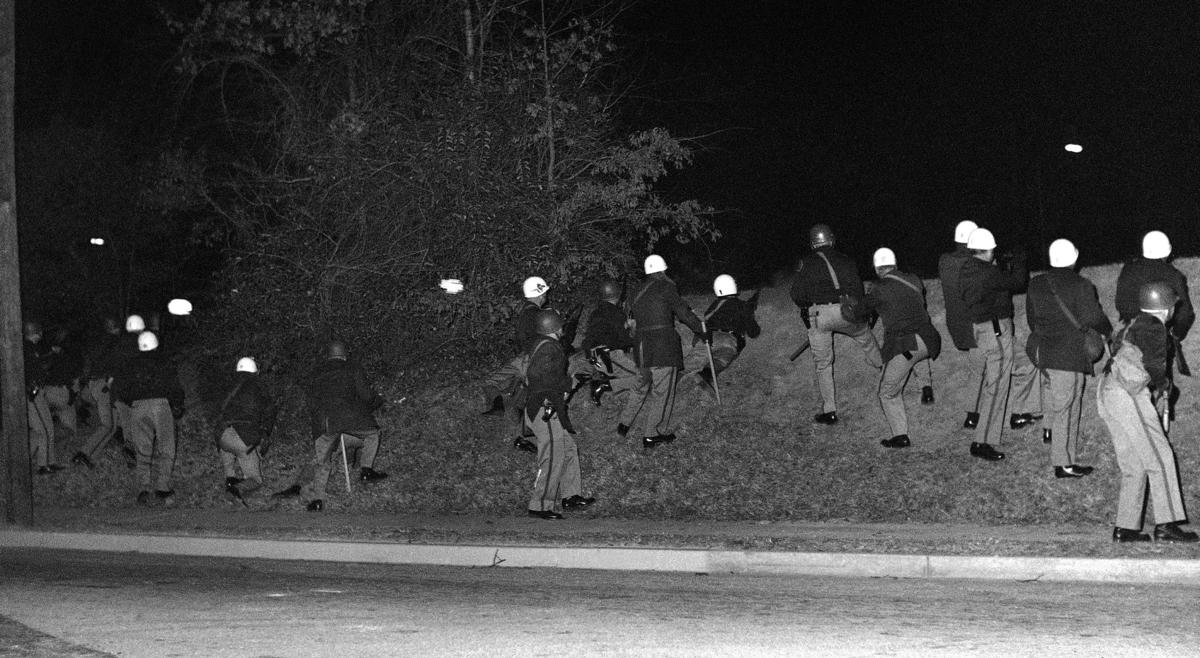 Highway Patrolmen advance take positions on an embankment, shortly before opening fire on student protestors.
