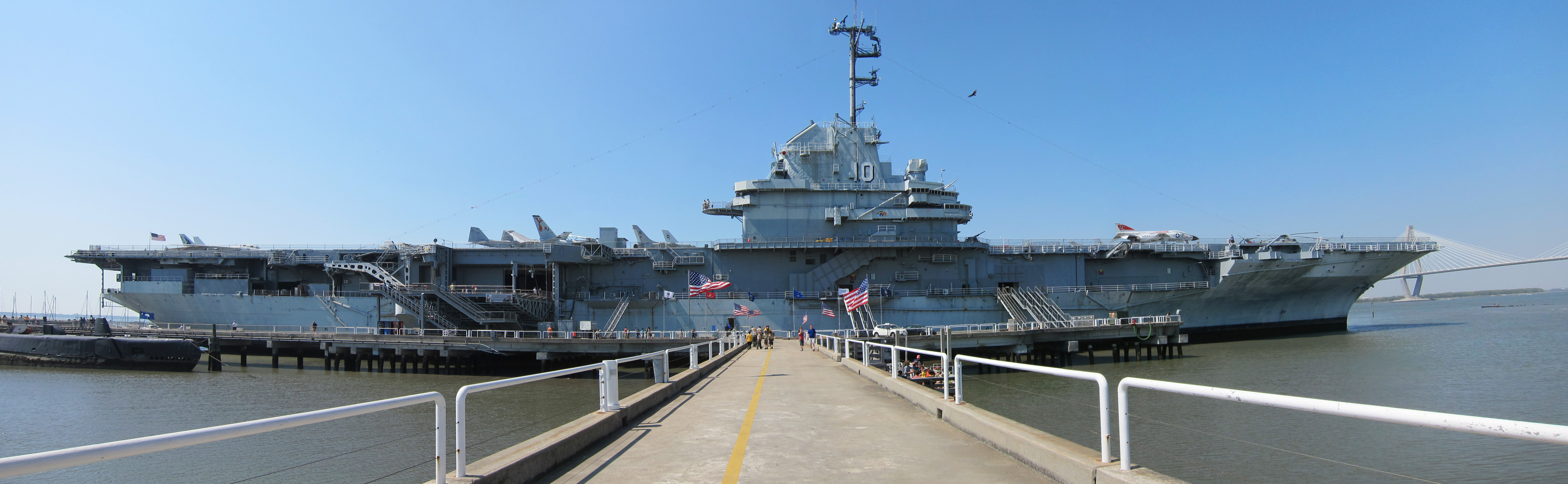 A panoramic image of the USS Yorktown (CVS-10) as she sits at Patriots Point in Mount Pleasant, South Carolina (USA) in March 2011. The stern of the USS Clamagore (SS-343) can be seen in the lower left, while the Arthur Ravenel Jr. Bridge can be seen crossing the Cooper River on the right.
