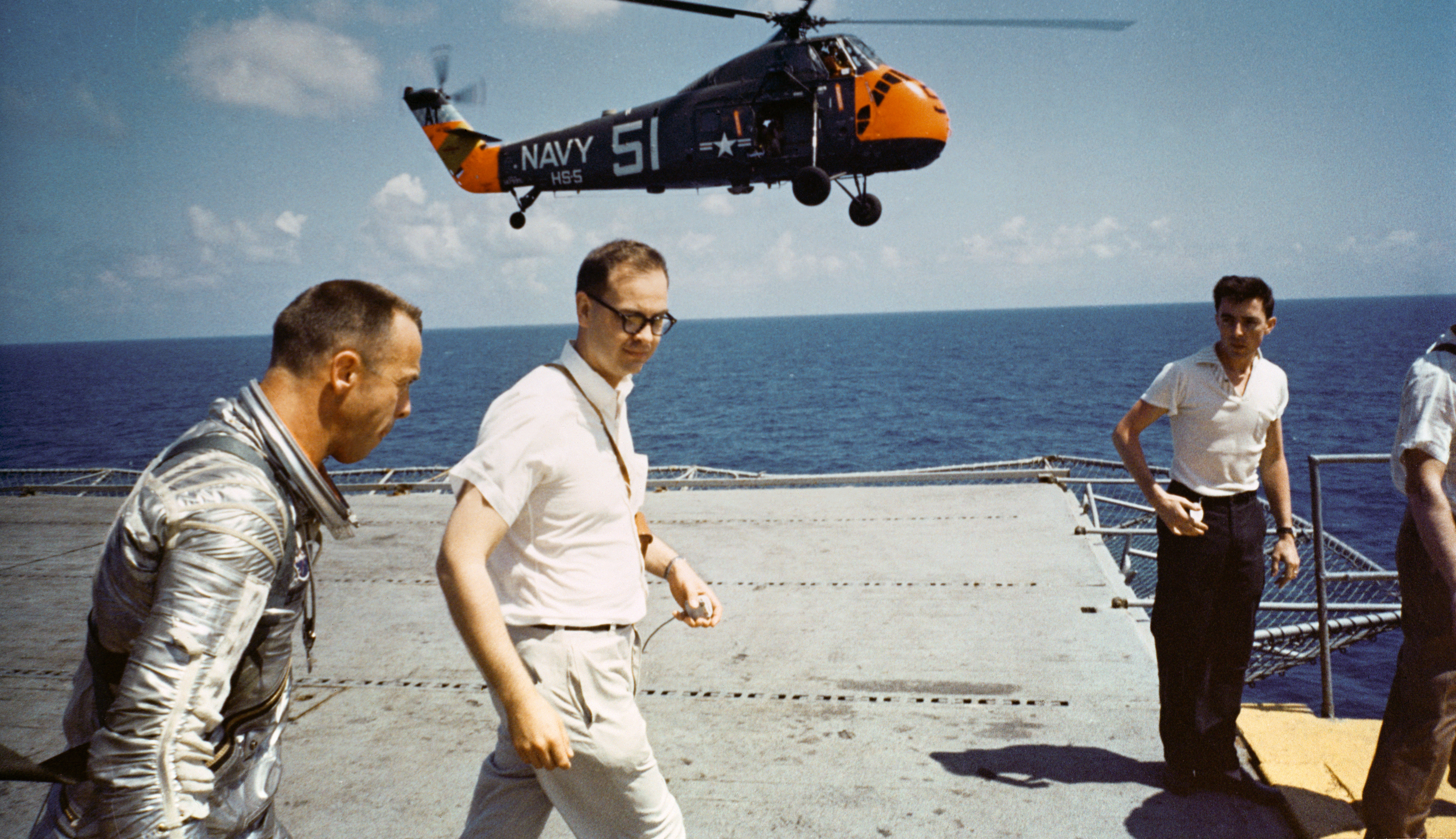 The U.S. astronaut Alan B. Shepard on the deck of the aircraft carrier USS Lake Champlain (CVS-39) after the recovery of his Freedom 7 Mercury space capsule, 5 May 1961. In the background is a Sikorsky HSS-1N Seabat helicopter of helicopter anti-submarine squadron HS-5 Night Dippers, Carrier Anti-Submarine Air Group 54 (CVSG-54).