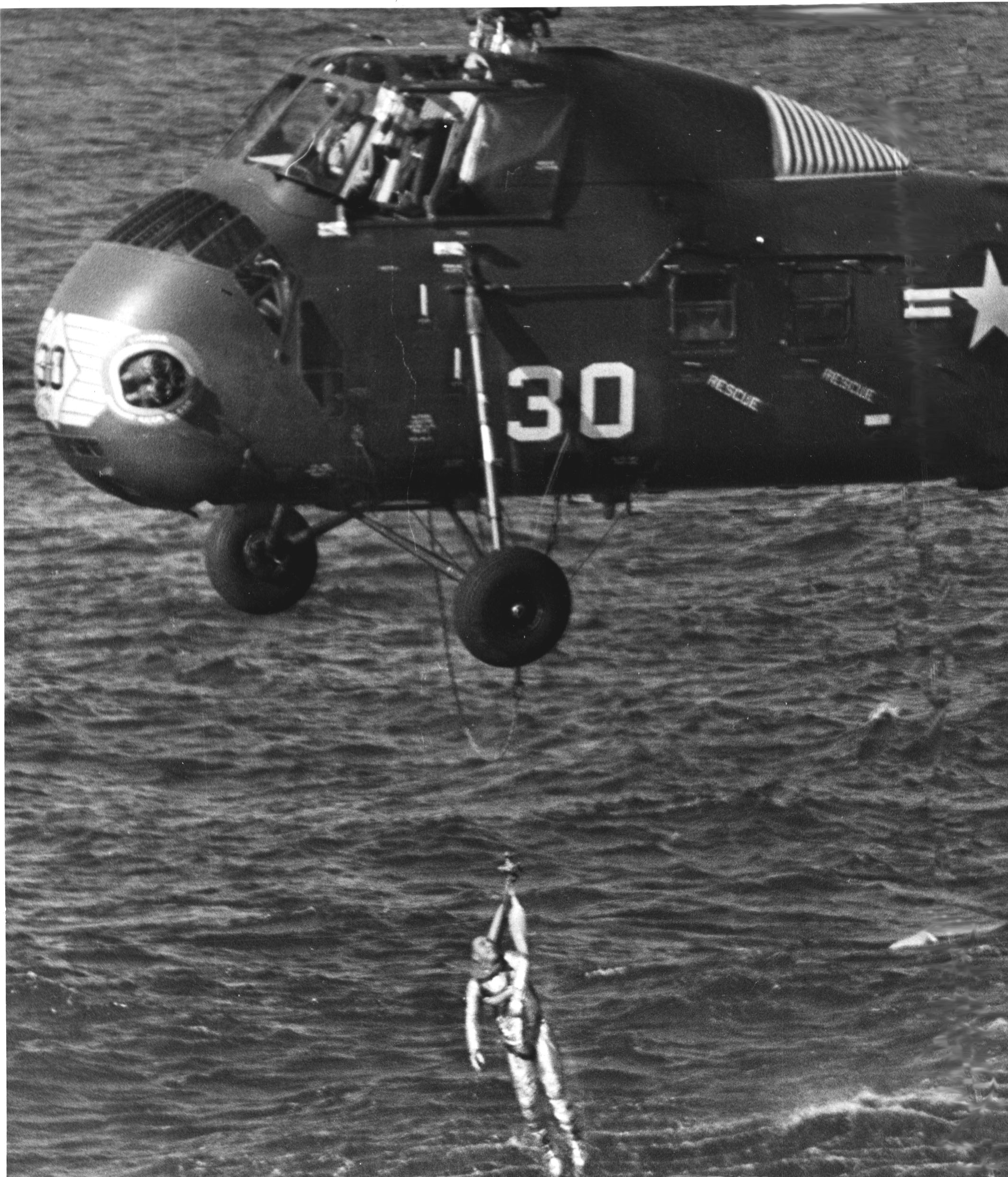 Marine helicopter has astronaut Virgil I. Grissom in harness and is bringing him up out of the water. The Liberty Bell 7 spacecraft has just sunk below the water. His Mercury-Redstone 4 launch was the second in the U.S. manned space effort. The helicopter is a Sikorsky HUS-1 Seahorse of Marine medium transport squadron HMR(L)-262 Det. Flying Tigers.
