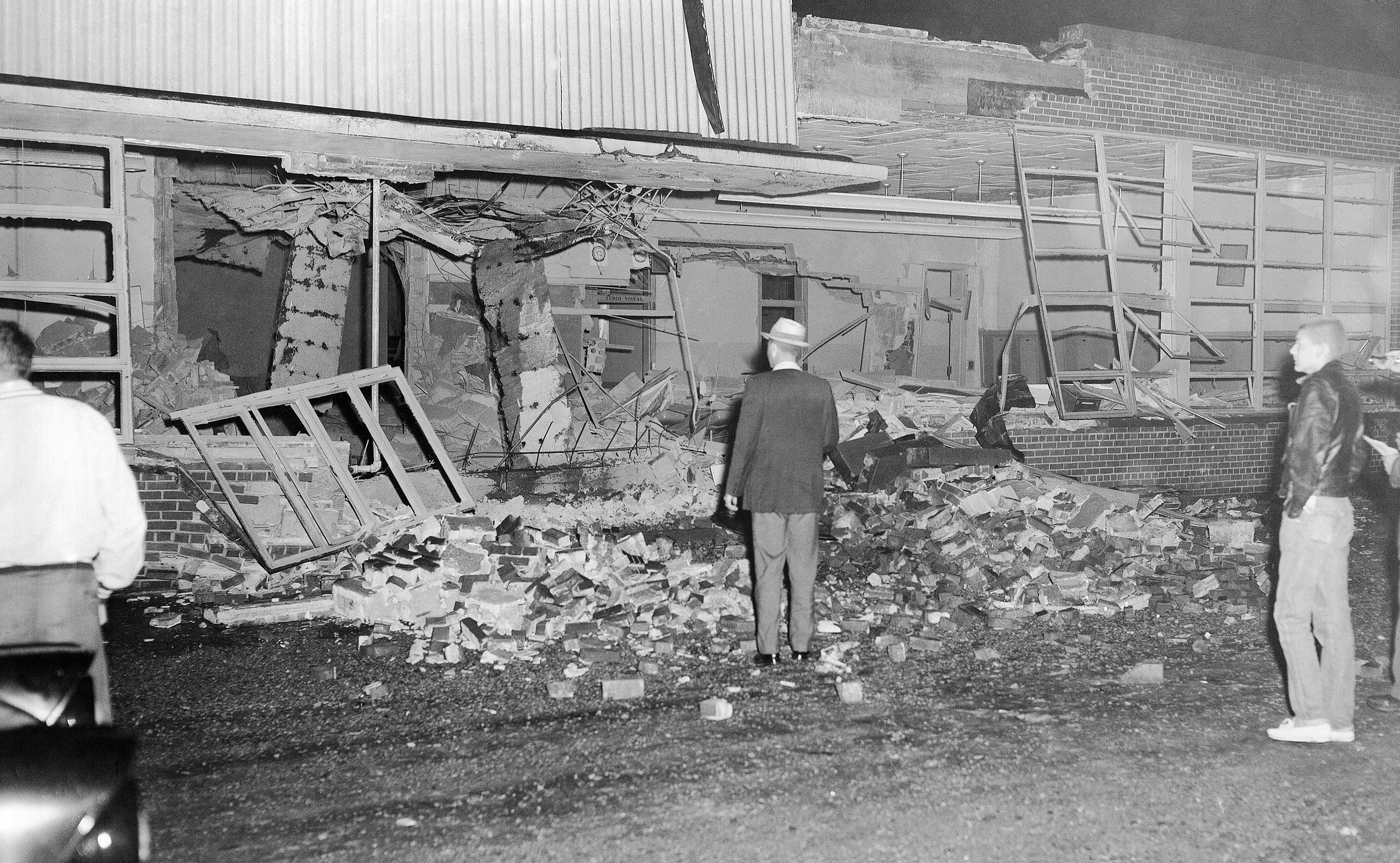 Original caption by the Associated Press: Onlookers stand in front of gaping hole torn in east wall of Hattie Cotton grammar school by a dynamite blast in Nashville, Tenn., Sept. 10, 1957. Police later roped off area to keep sightseers from premises. Hattie Cotton was one of six Nashville elementary schools admitting Negroes and whites together in the first grade.