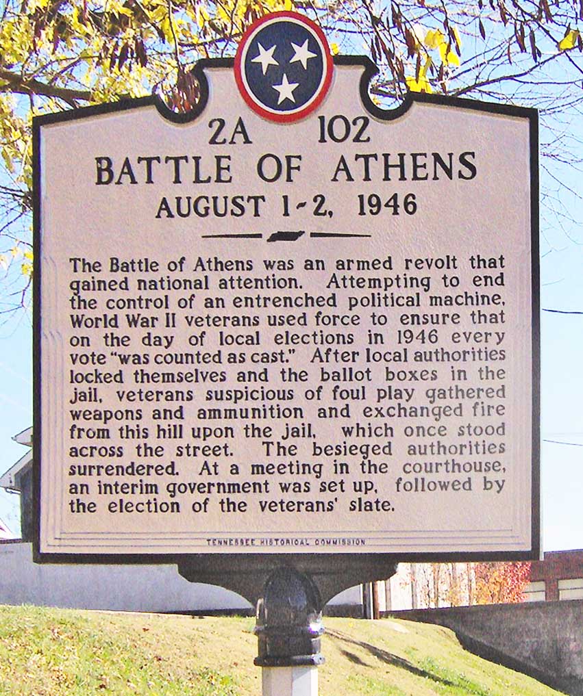 Tennessee Historical Commission marker in Athens, Tennessee, in the southeastern United States. The marker recalls the "Battle of Athens," which occurred on August 2, 1946, when local officials locked themselves in the old jail (formerly off-camera to the right), allegedly to fix election results. An armed group of World War II veterans and supporters assembled on the hill to the left and exchanged fire with the authorities in the jail.