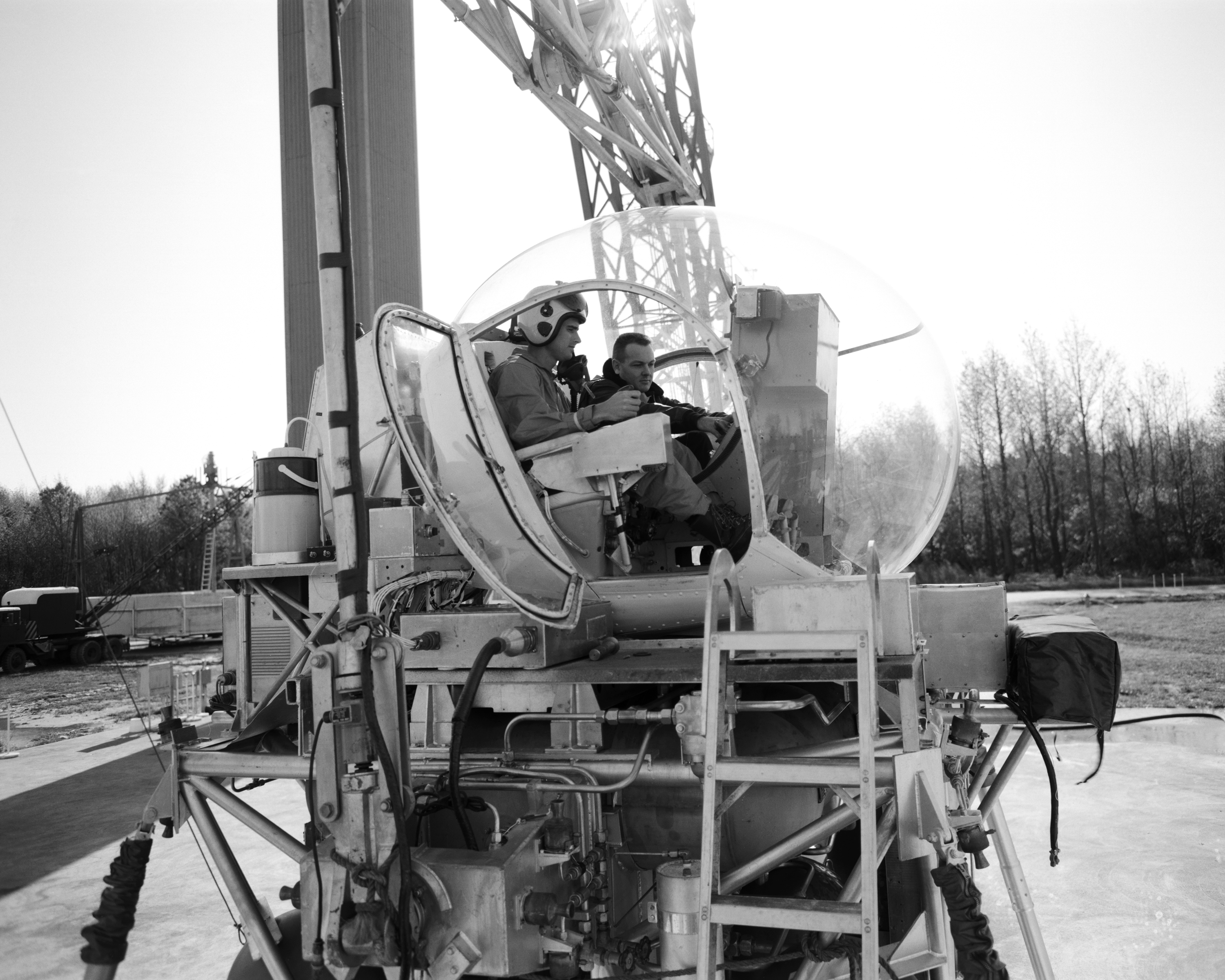 Astronaut Roger B. Chaffee (left) receives instruction from Maxwell W. Goode, a scientist at NASA's Langley Research Center. Goode is explaining the operation of the Lunar Landing Simulator at the Lunar Landing Research Facility.