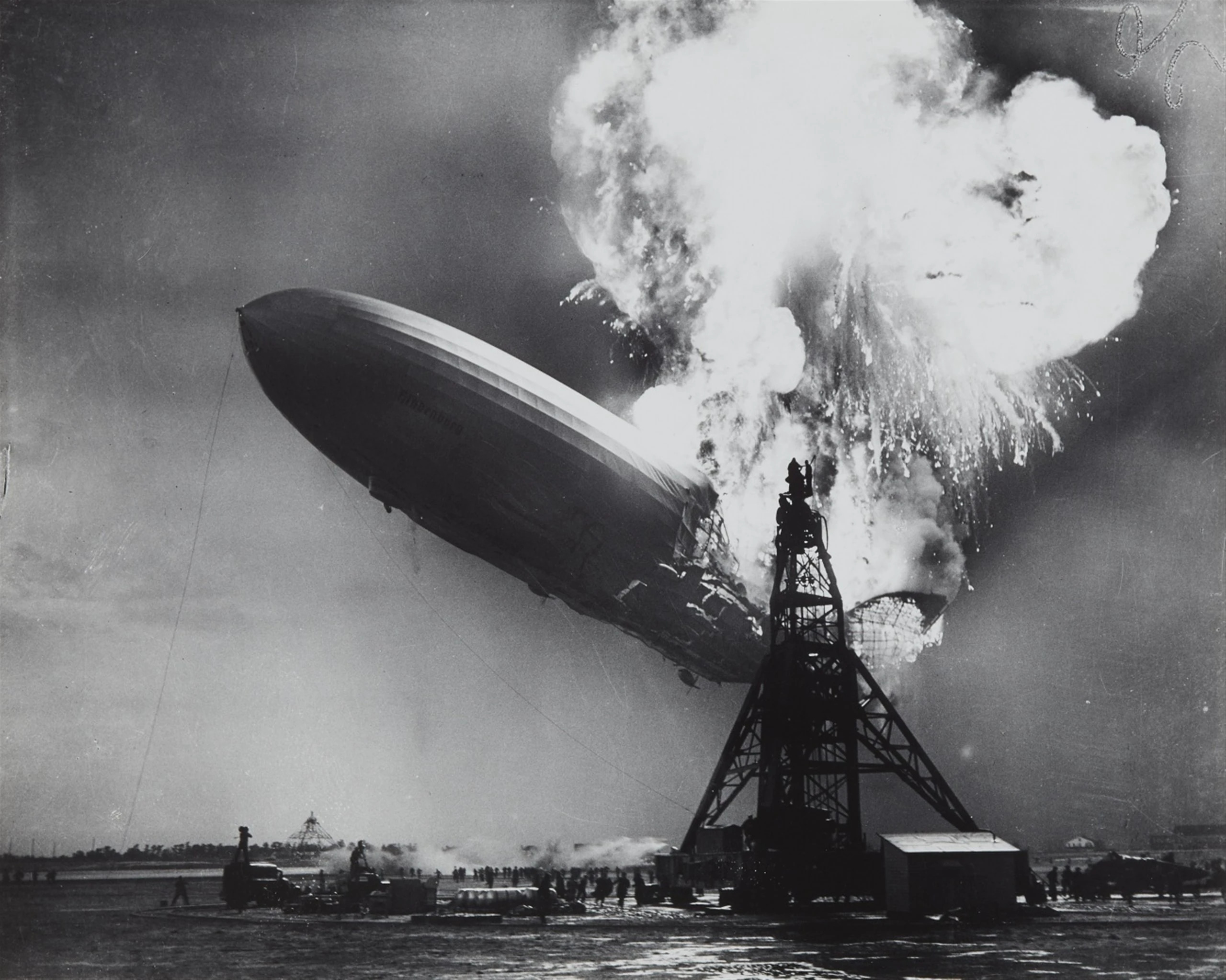 The German airship (zeppelin) Hindenburg on fire at the mooring mast at Lakehurst New Jersey, United States of America, 6 May 1937. Ballast water is being dropped. The end of the airships.
