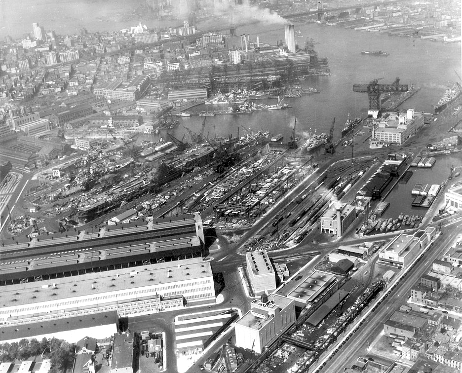 Aerial view of the U.S. Navy New York Naval Shipyard on 15 April 1945. There are four aircraft carriers under construction: USS Reprisal (CV-35) in Dry Dock No. 6; USS Coral Sea, later renamed USS Franklin D. Roosevelt (CVB-42) in Dry Dock No. 5; USS Kearsarge (CV-33); USS Oriskany (CV-34) (not visible behind Kearsarge).