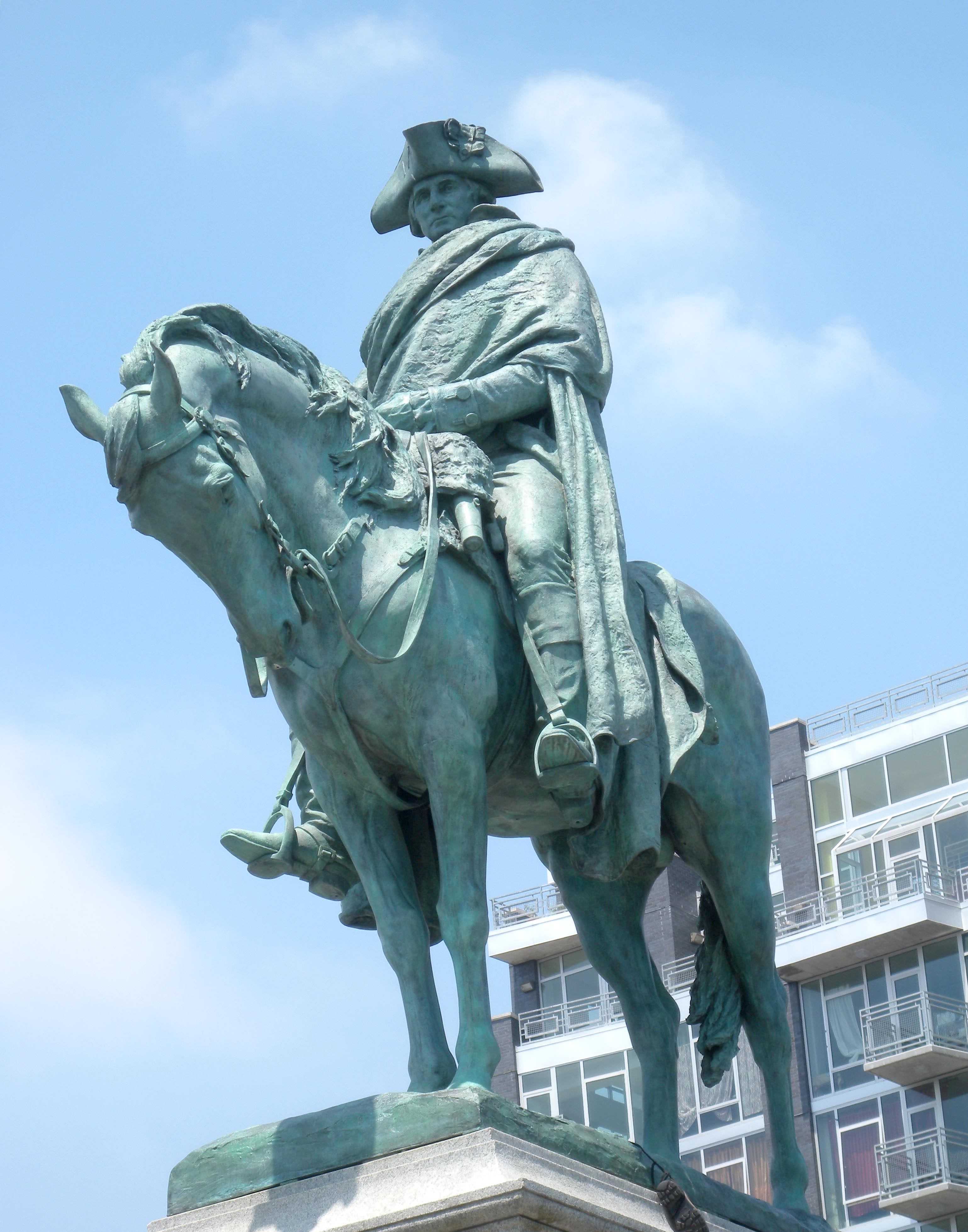Looking northwest at statue of Geo Washington in Continental Army Plaza, on the north side of South 5th Street and the ramps feeding the Brooklyn side of the Williamsburg Bridge, on a sunny midday.