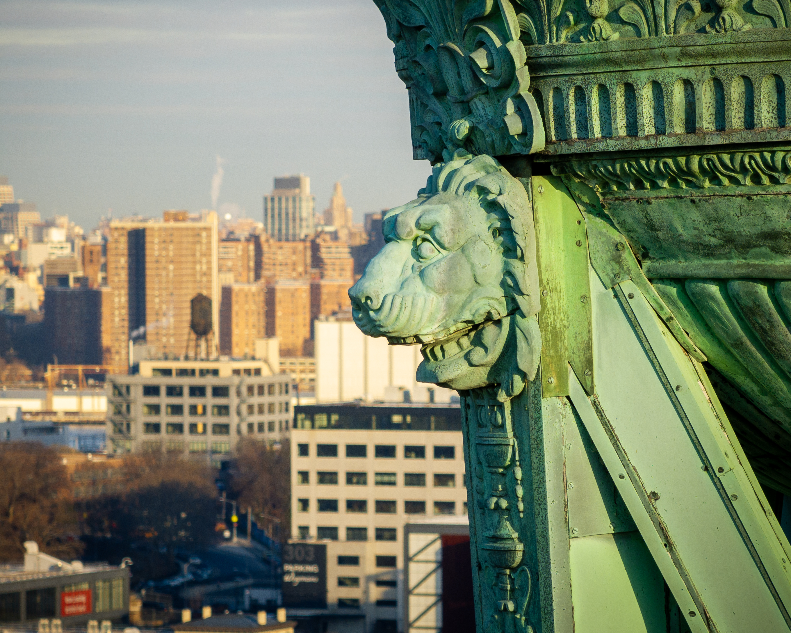 A close-up photo of a lion head sculpture, part of the brazier on the Prison Ship Martyrs' Monument in Fort Greene Park, Brooklyn.