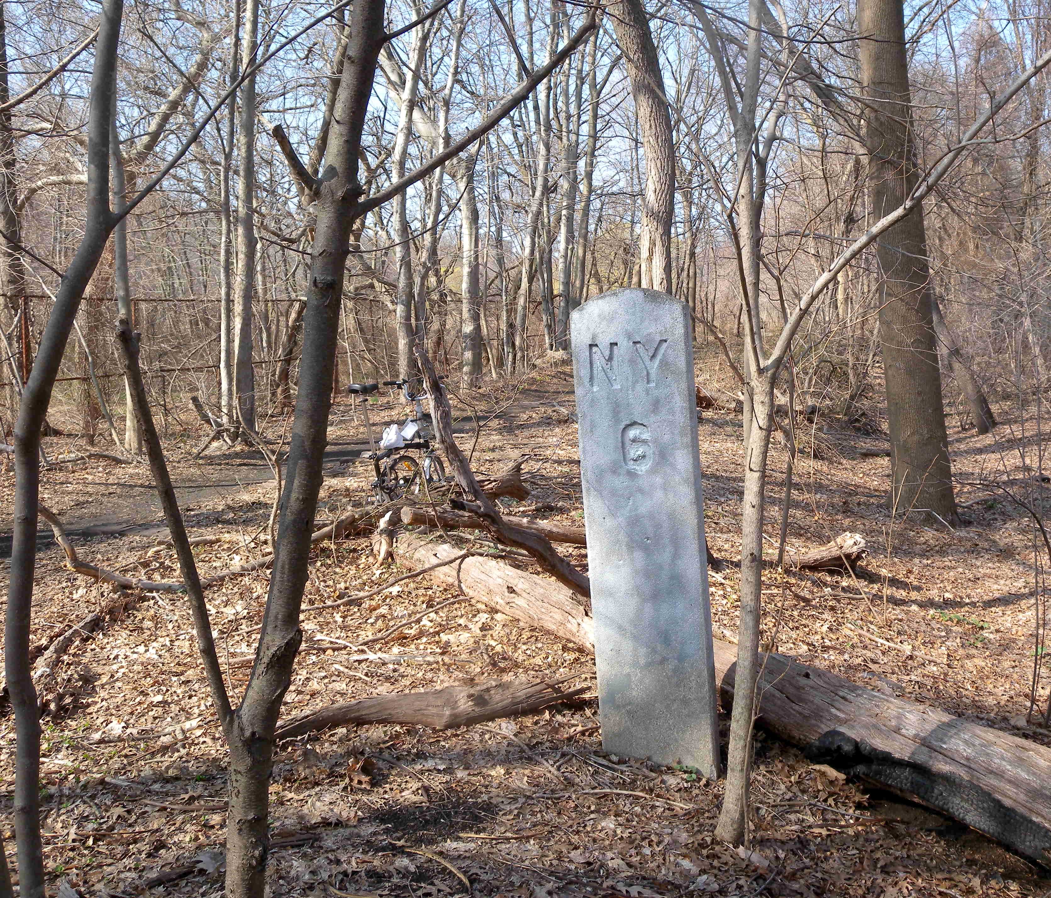 Looking north at Milestone 6 of en:New York and Putnam Railroad in en:Van Cortlandt Park on a sunny midday.