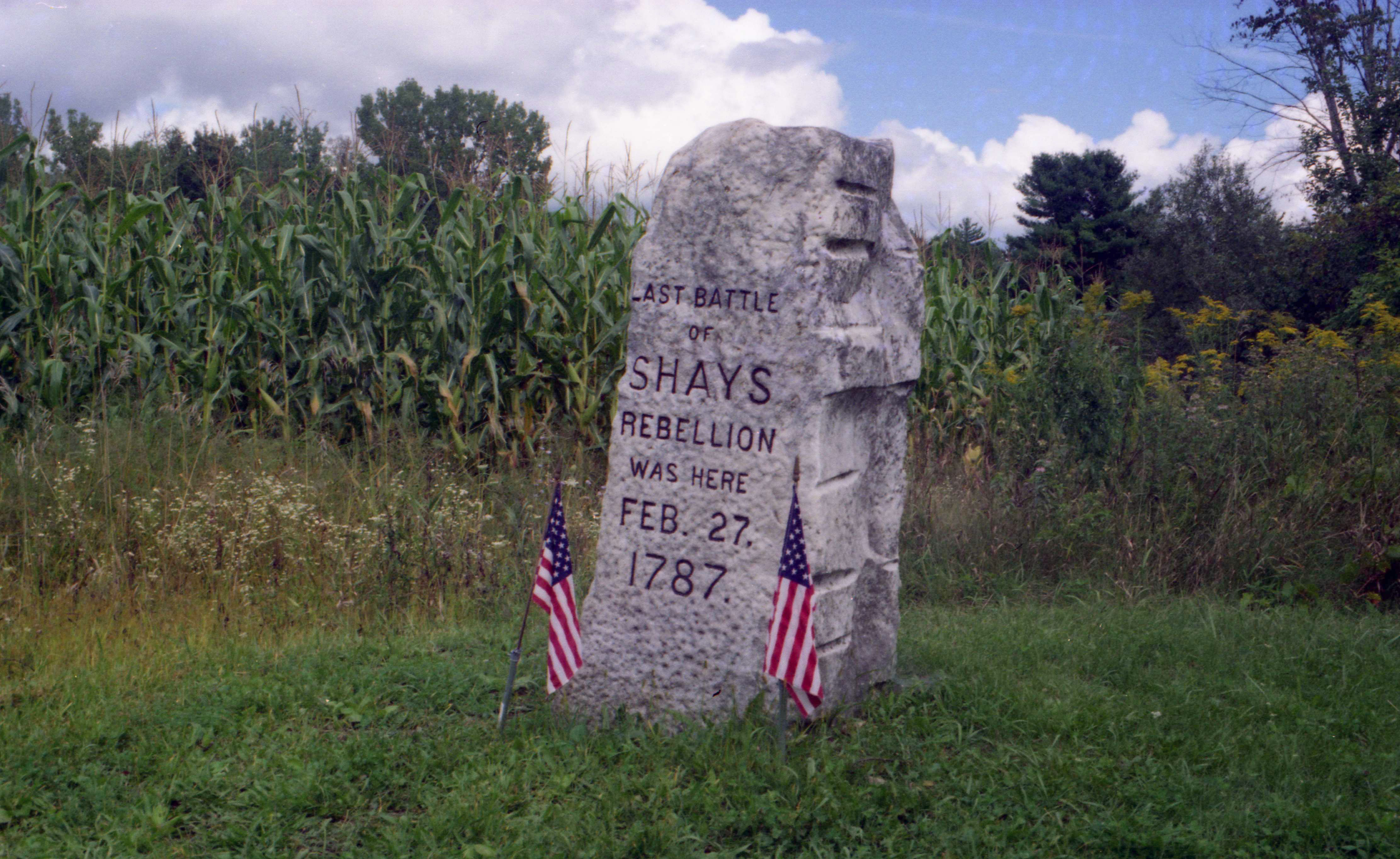A stone monument resembling a gravestone in a field in Sheffield, Massachusetts commemorating the final battle of Shays' Rebellion. The text on the monument reads 'Last battle of Shays rebellion was here Feb. 27, 1787.'