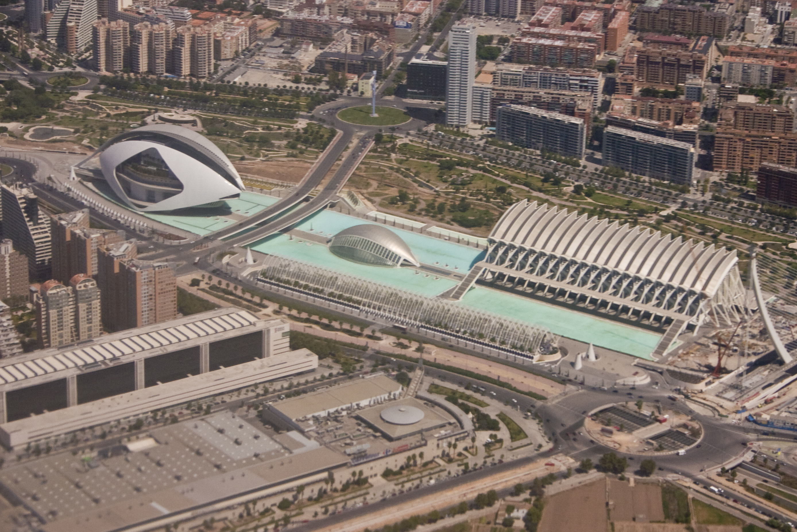 An aerial image taken from a Boeing 737 on the EMA to VLC flight path of The Ciutat de les Arts i les Ciències (Valencian), Ciudad de las Artes y las Ciencias (Spanish) or City of Arts and Sciences. The buildings are situated in the Turia Gardens, a dry river bed of the now diverted River Turia in Valencia, Spain. The image depicts: El Palau de les Arts Reina Sofía (opera house and performing arts centre), L'Hemisfèric (Imax Cinema, Planetarium and Laserium), L'Umbracle (walkway / Garden) and El Museu de les Ciències Príncipe Felipe (science museum). Taken using Canon 300D, ISO 100, 55mm (18-55mm), f/8, 1/1500 sec