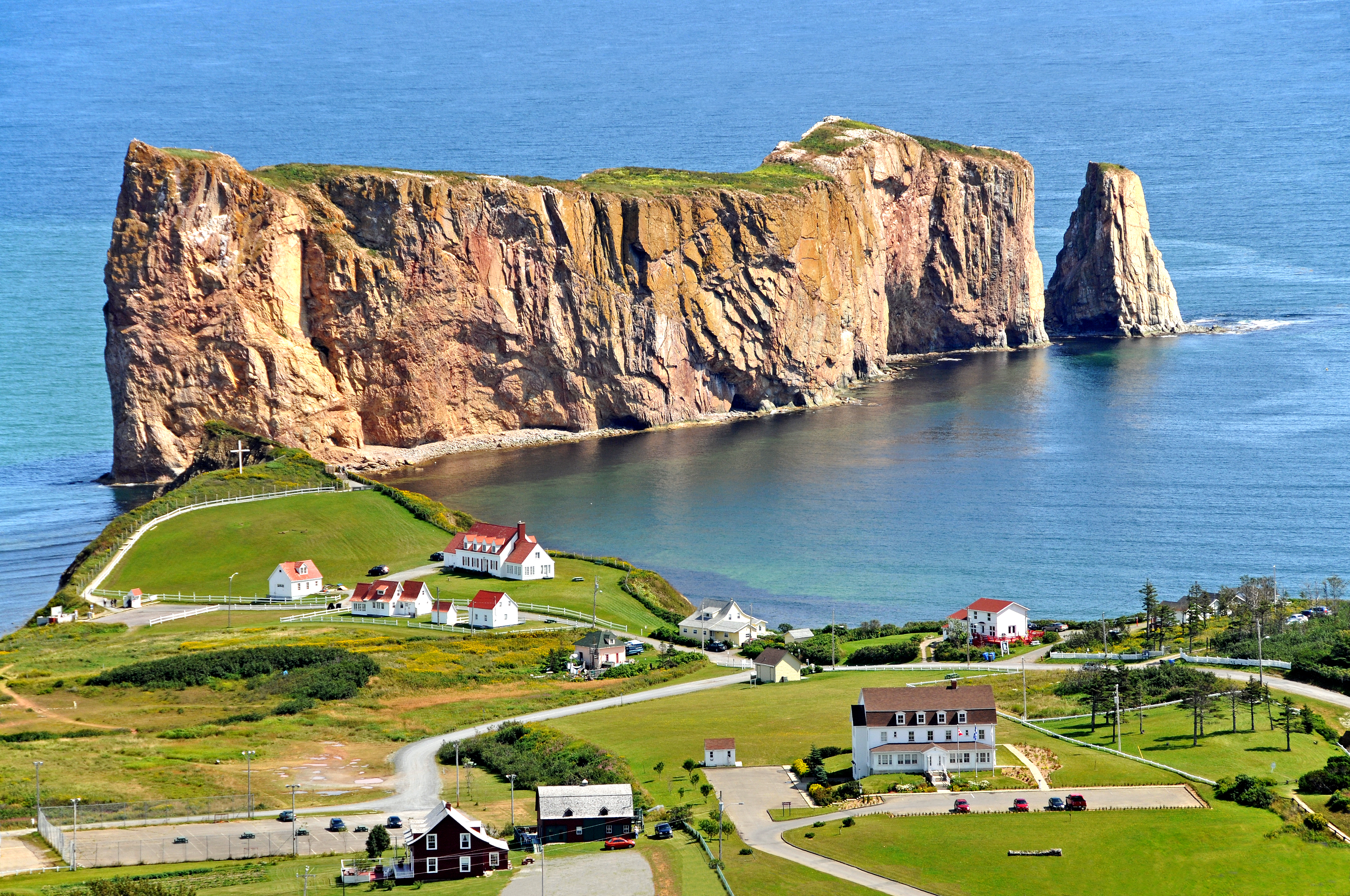 Percé (2006 Population 3,419) is a small village near the tip of the Gaspé Peninsula in Québec. It has a long history of being an important seasonal fishing centre under the French. Today the area is mainly a tourist location particularly well-known for the attractions of Percé Rock and Bonaventure Island.
Percé Rock is a natural rock formation located close to the shore facing the town. It is a natural tourist attraction for its size, color, and unusual door-like hole at one end the rock.