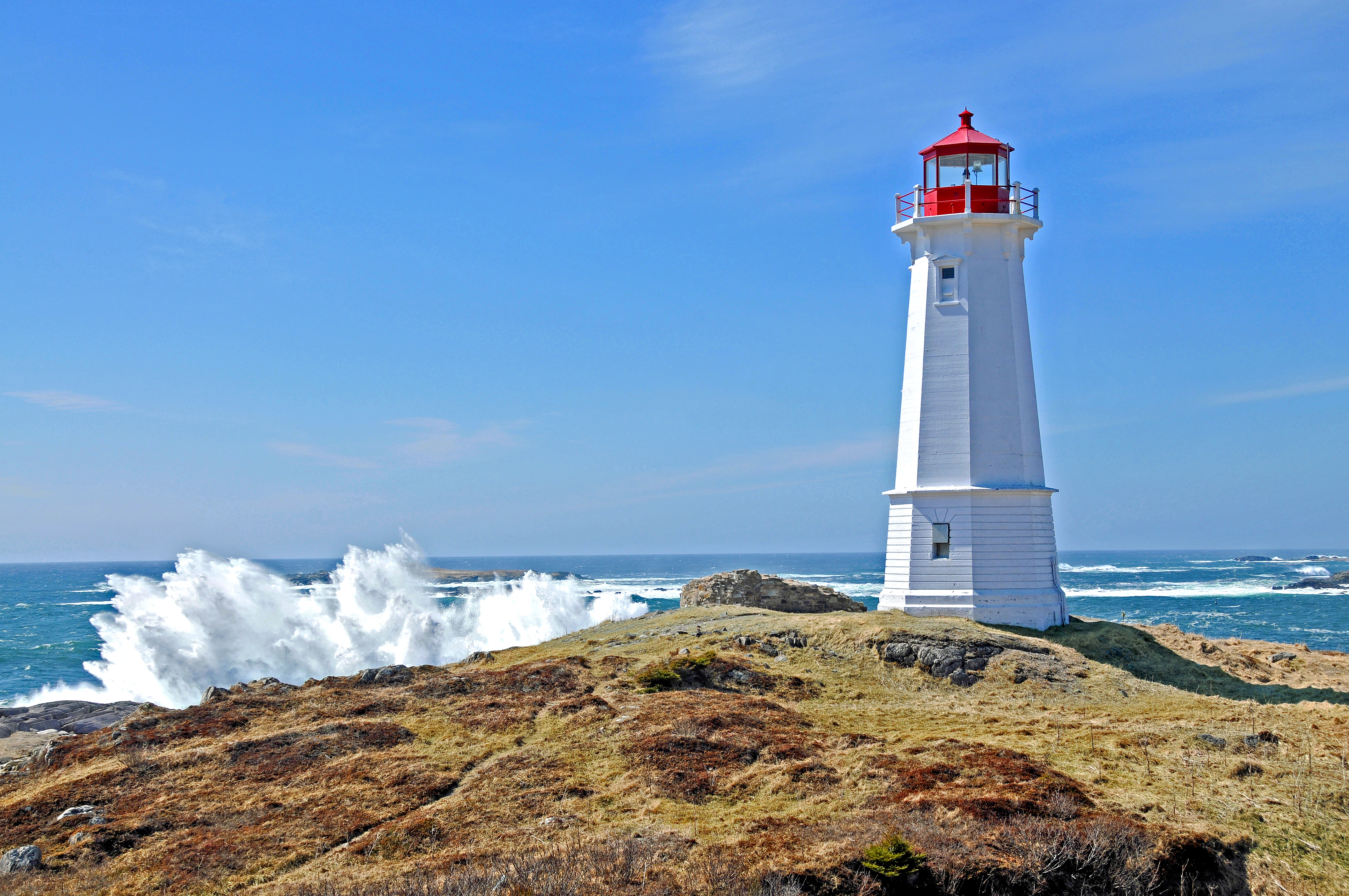 Louisbourg Lighthouse, 2008. This is the third light and was completed in 1923, a year after the second light burned. It is a white concrete octagonal tower, 55 feet high. Several modifications have been made to the characteristic of the light over time. Louisbourg, Nova Scotia, Canada
The lighthouse constructed by the French at Louisbourg was the first established in Canada, and the second on the North American continent. (The first North American light was lit on September 14, 1716 on Little Brewster Island in Boston Harbour.) Louisbourg, built near the northeast corner of Cape Breton Island, was the base from which the French planned to hold New France against the English. The Fortress was dependant upon ships from France to supply most of its needs. Safe entrance to the harbour at the end of the long voyage became a concern. 
The initial plan to build a tower and light was made in late 1727, though the formal decision to build was not made until spring of 1729, after one of the King's ships, Le Profond nearly met its end in the harbour which was marked only by a navigational cross, and periodically by a bonfire.