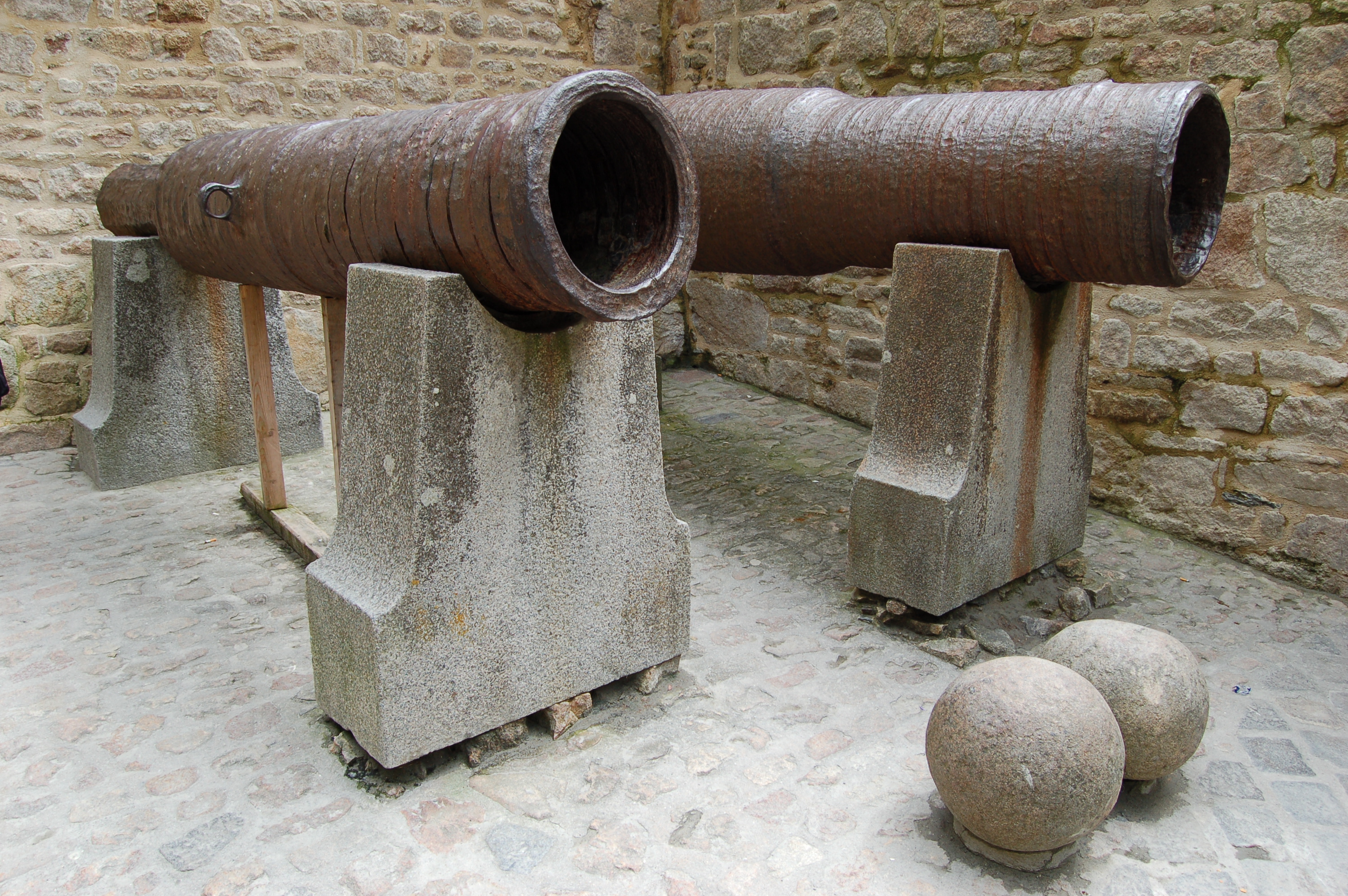 Photograph of the cannons abandonded by Thomas Scalles at Mont Saint-Michel on 17 June 1434.  Marked by an explanatory plaque with the words: BOMBARDES ANGLAISES ABANDONNEES PAR L'ARMEE DE THOMAS SCALLES LE 17 JUIN 1434 "CALIBRE 380 - 420"