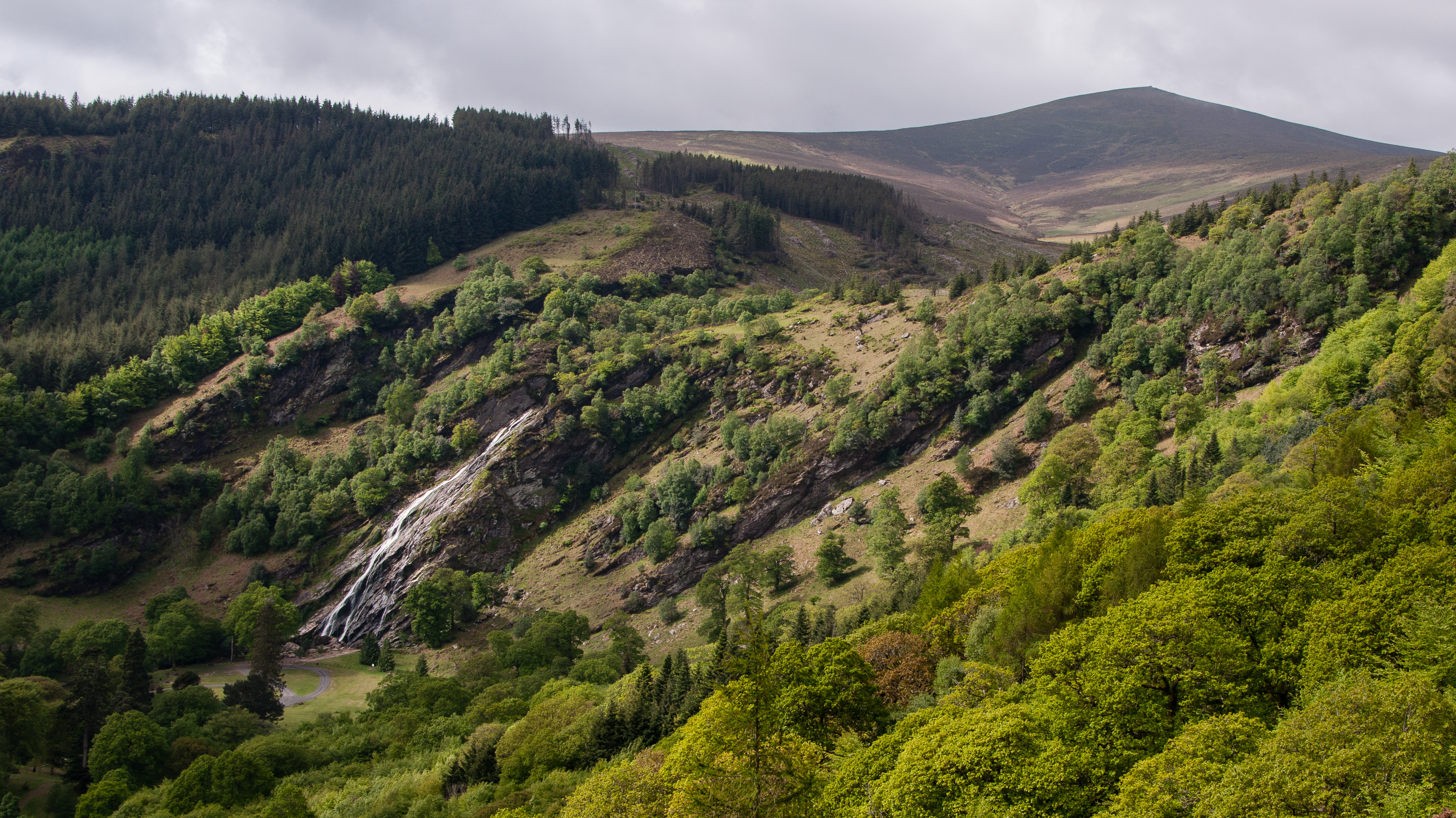 View of Powerscourt Deerpark and Waterfall at Ride Rock, Crone Woods near Enniskerry, County Wicklow, Ireland. At 121 metres, the waterfall is the tallest in Ireland. It is fed by the River Dargle which rises in the Glensoulan valley near Djouce mountain, which can be seen in background.