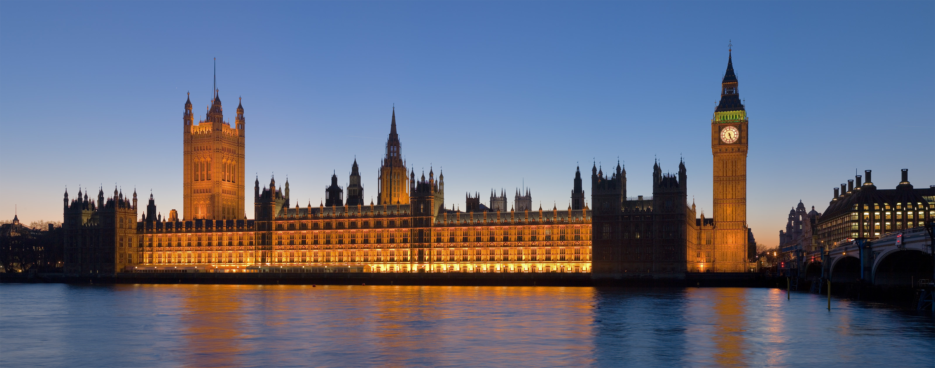 The Palace of Westminster at night as seen from the opposite side of the River Thames. Victoria Tower and the House of Lords is on the left. The Clock Tower of Big Ben and the House of Commons is on the right. The spire left of centre is the 300ft ventilation chimney above the central lobby. The twin towers with flagless pole just visible in the background is Westminster Abbey. A 2 x 6 segment panoramic image taken by myself with a Canon 5D and 85mm f/1.8 lens.