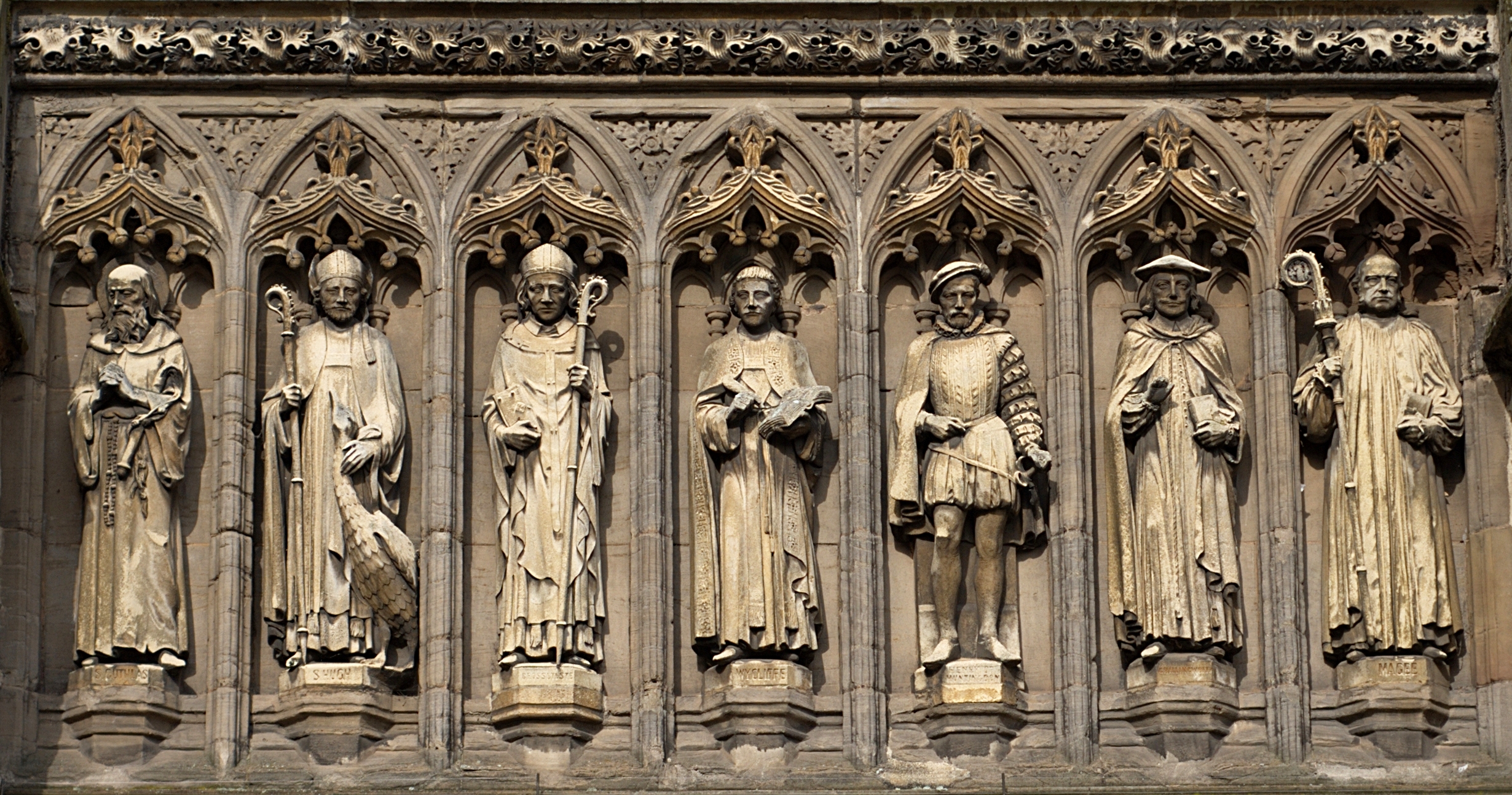 Detail from the Vaughan Porch [1] of Leicester Cathedral. The seven statues are (left to right) of St Guthlac, St Hugh of Lincoln, Robert Grosseteste, John Wycliffe, Henry Hastings, William Chillingworth and William Connor Magee.