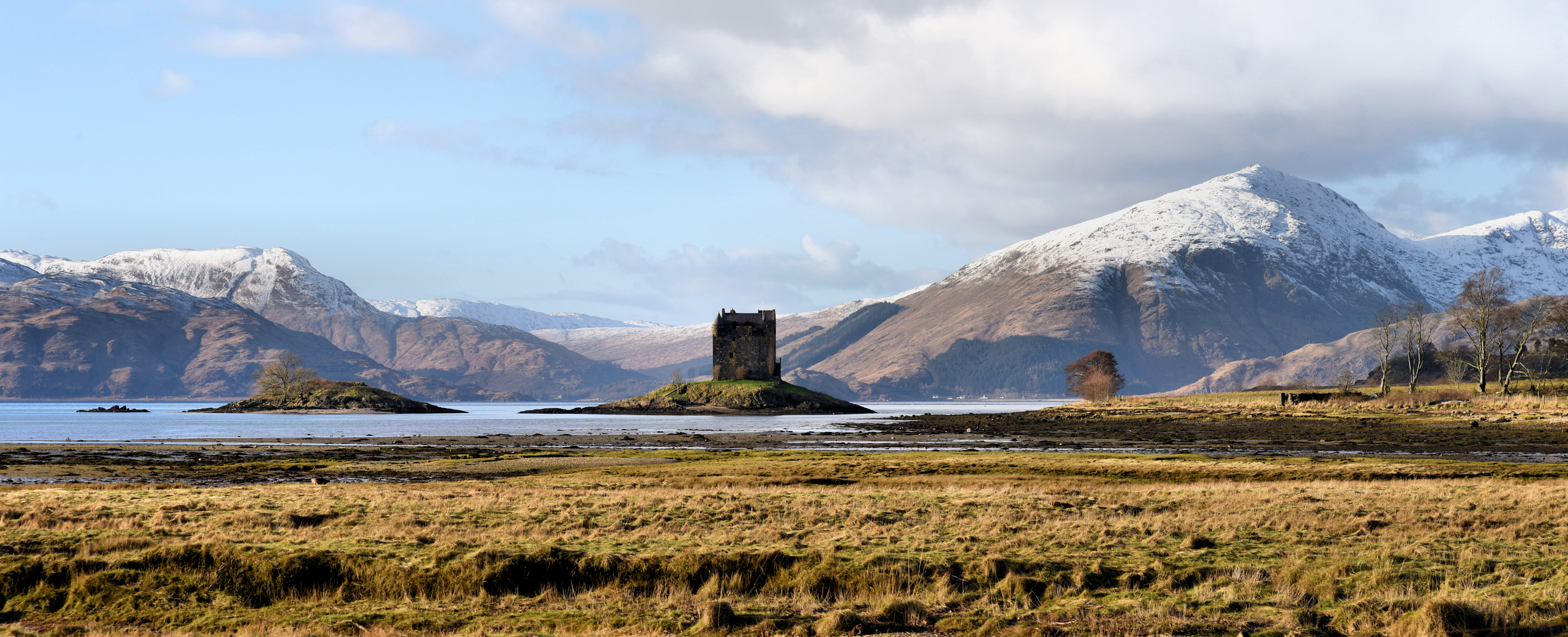 A view of Loch Laich and Castle Stalker with the mountains of the Ardnamurchan peninsula in the background.