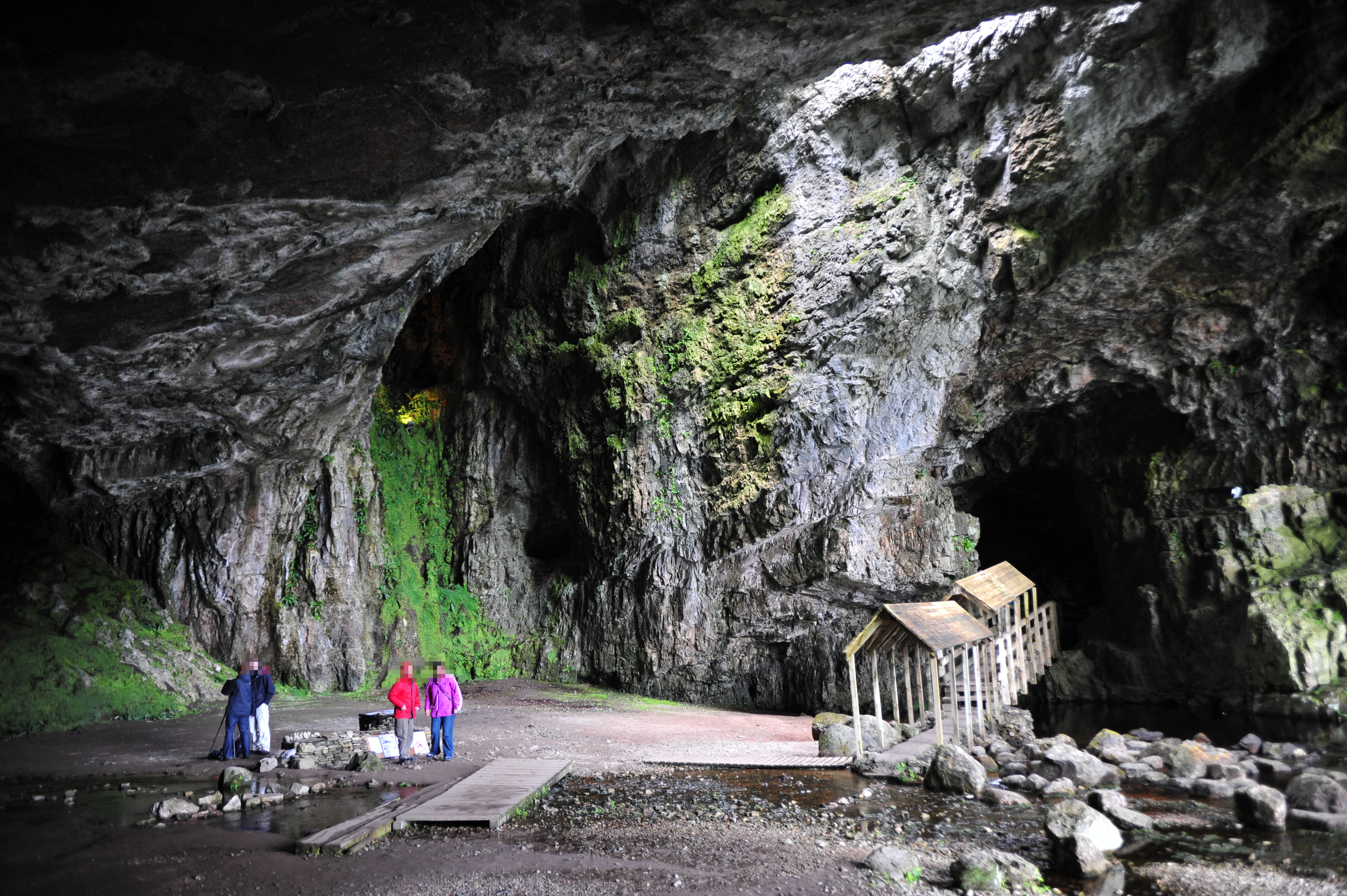 Outer chamber of Smoo Cave, Scotland. The main entrance is to the right; the covered walkway leads to the second (inner) chamber with the waterfall.