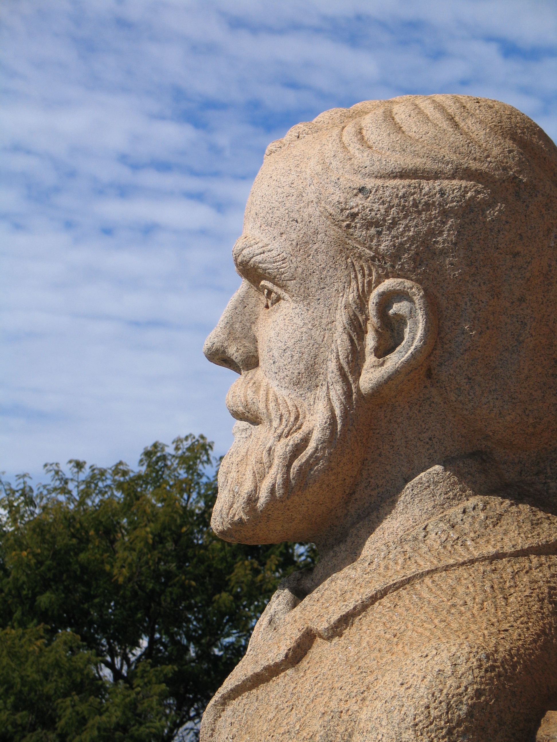 Head of the granite statue of Piet Retief, Governor of the Voortrekkers, at the northeastern corner of the Voortrekker Monument, Pretoria. It is one of four corner guards or colossi, each 5.5 m tall, forming a symbolic guard of honour, or prolegomena to the more specific stories depicted on the frieze panels.[1] Designed by Frikkie Kruger and sculpted by Skaris from granite quarried by firm Sinclair.