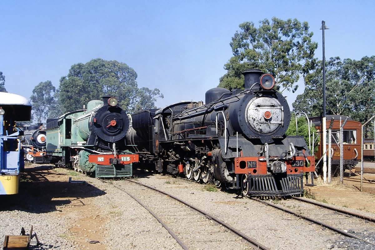 At the Zimbabwe National Railway Museum. No 115 a 9B class built by North British Locomotive Co in 1917 with manufacturer No 21478. Alongside, the 19th class No 330 built by Henschel in 1952 with manufacturer number 27400. In the background 11th class No 127.