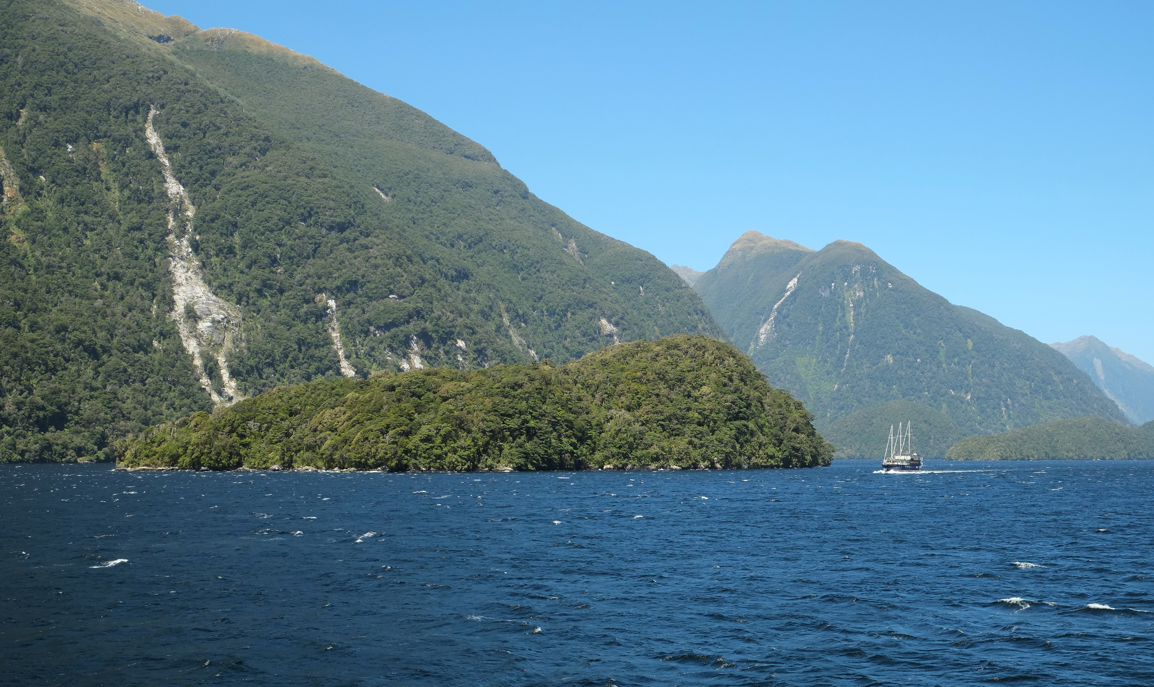 Fergusson Island in Doubtful Sound, with the Milford Mariner cruise boat next to it; Elizabeth Island in the distance on the right