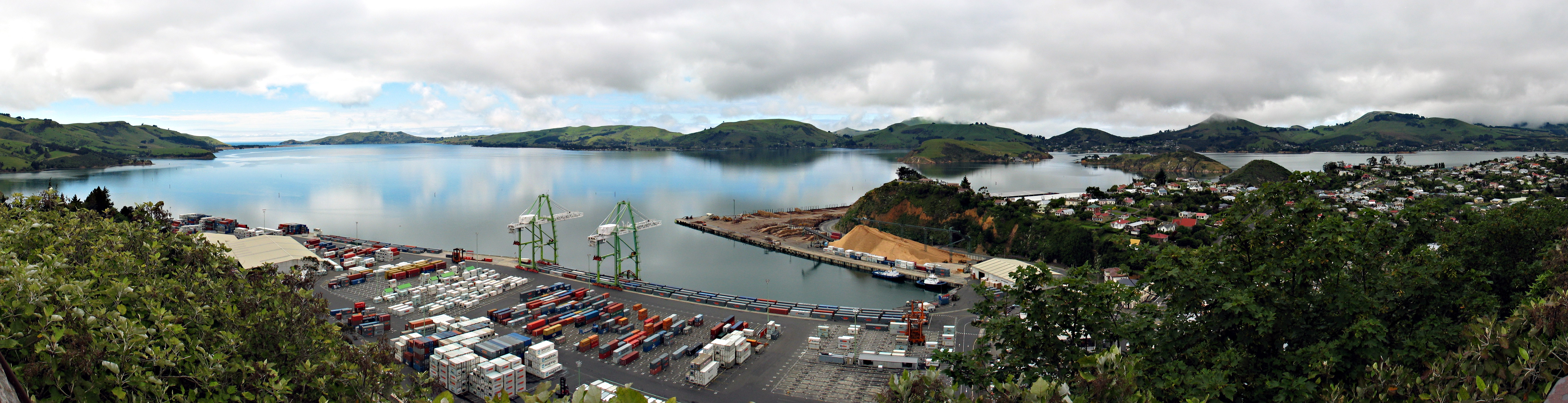 This is a panorama of the view from the Centennial Lookout overlooking Port Chalmers and its container terminal, in New Zealand. Port Chalmers is Dunedin's port.