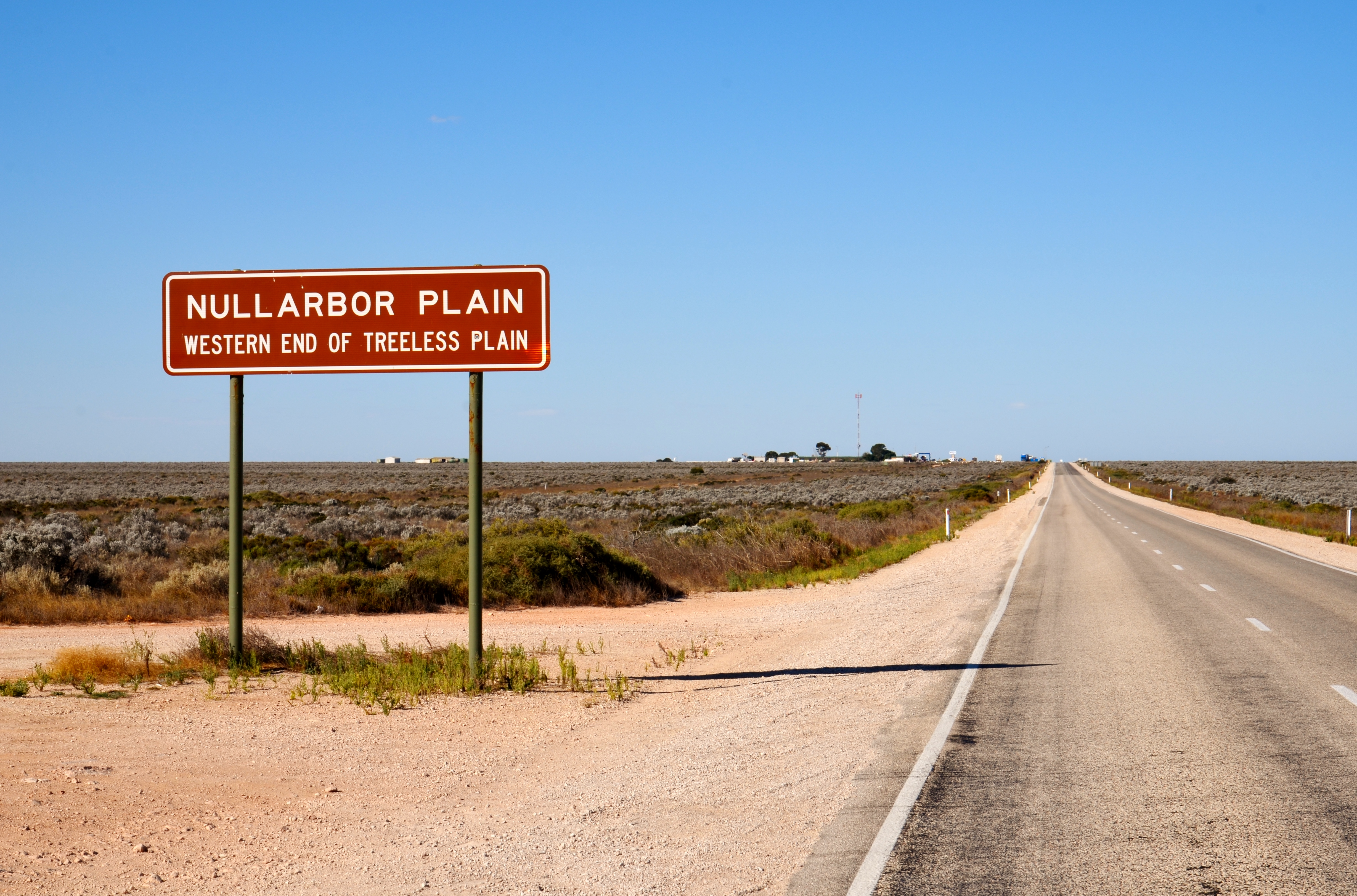 Highway sign on the Eyre Highway near Nullarbor, South Australia (which is visible in the background), marking the western end of the treeless plain.