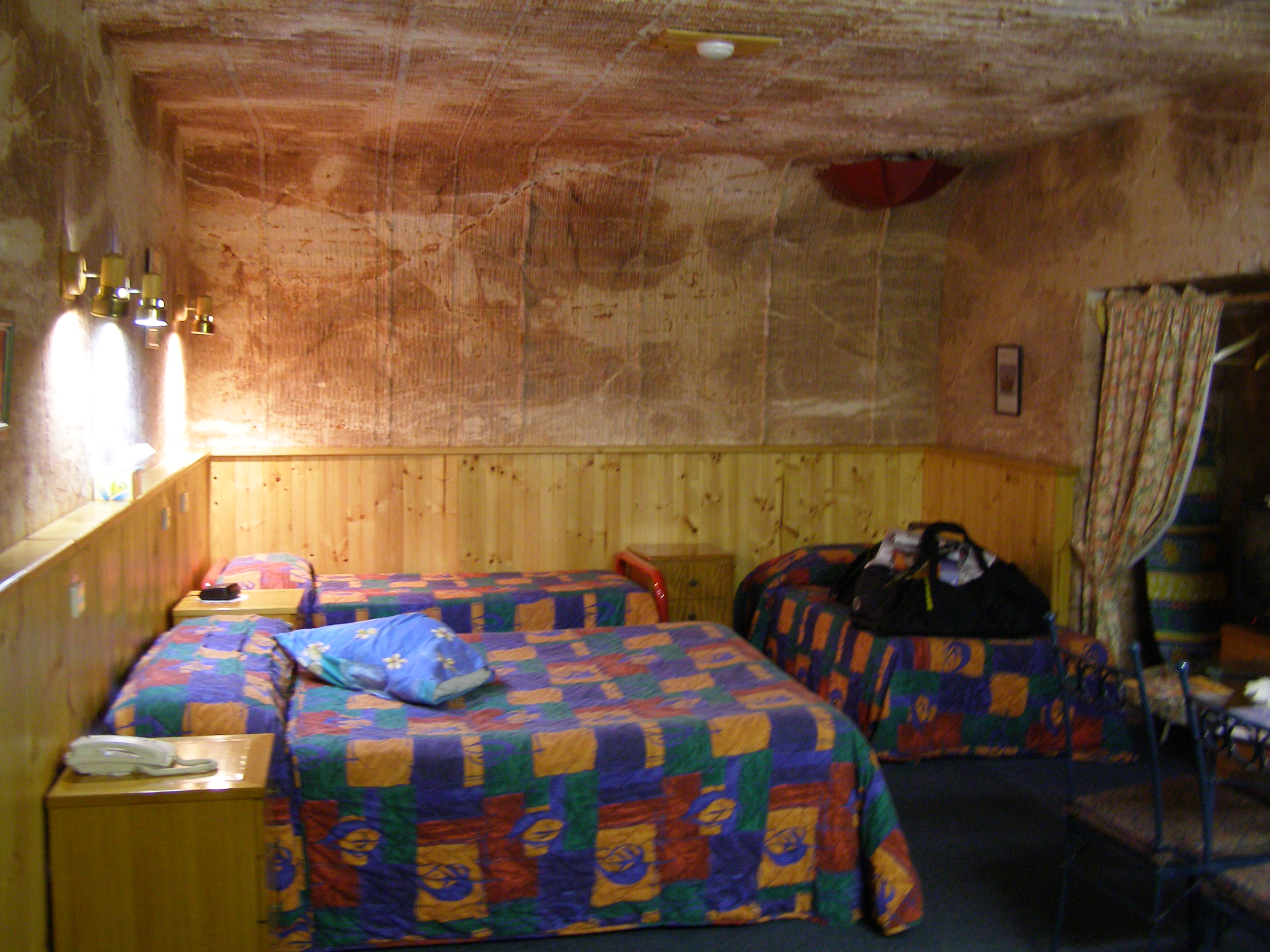 Coober Pedy underground motel room, 2007. The upside-down umbrella in the corner of the ceiling is used to catch the dirt that falls down the ventilation shaft from the surface.