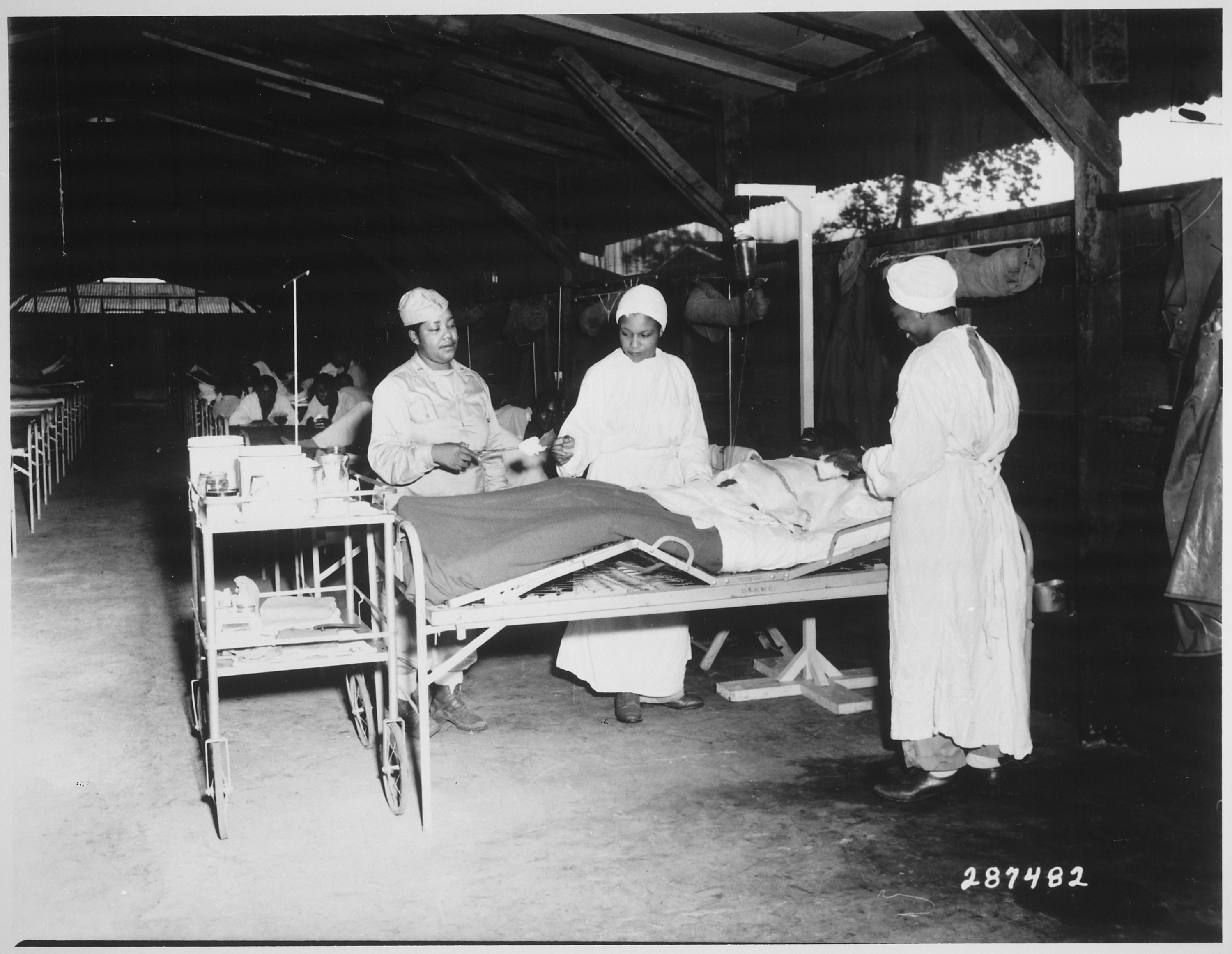 "Surgical ward treatment at the 268th Station Hospital, Base A, Milne Bay, New Guinea. Left to right, Sgt. Lawrence McKr - NARA - 530771.jpg