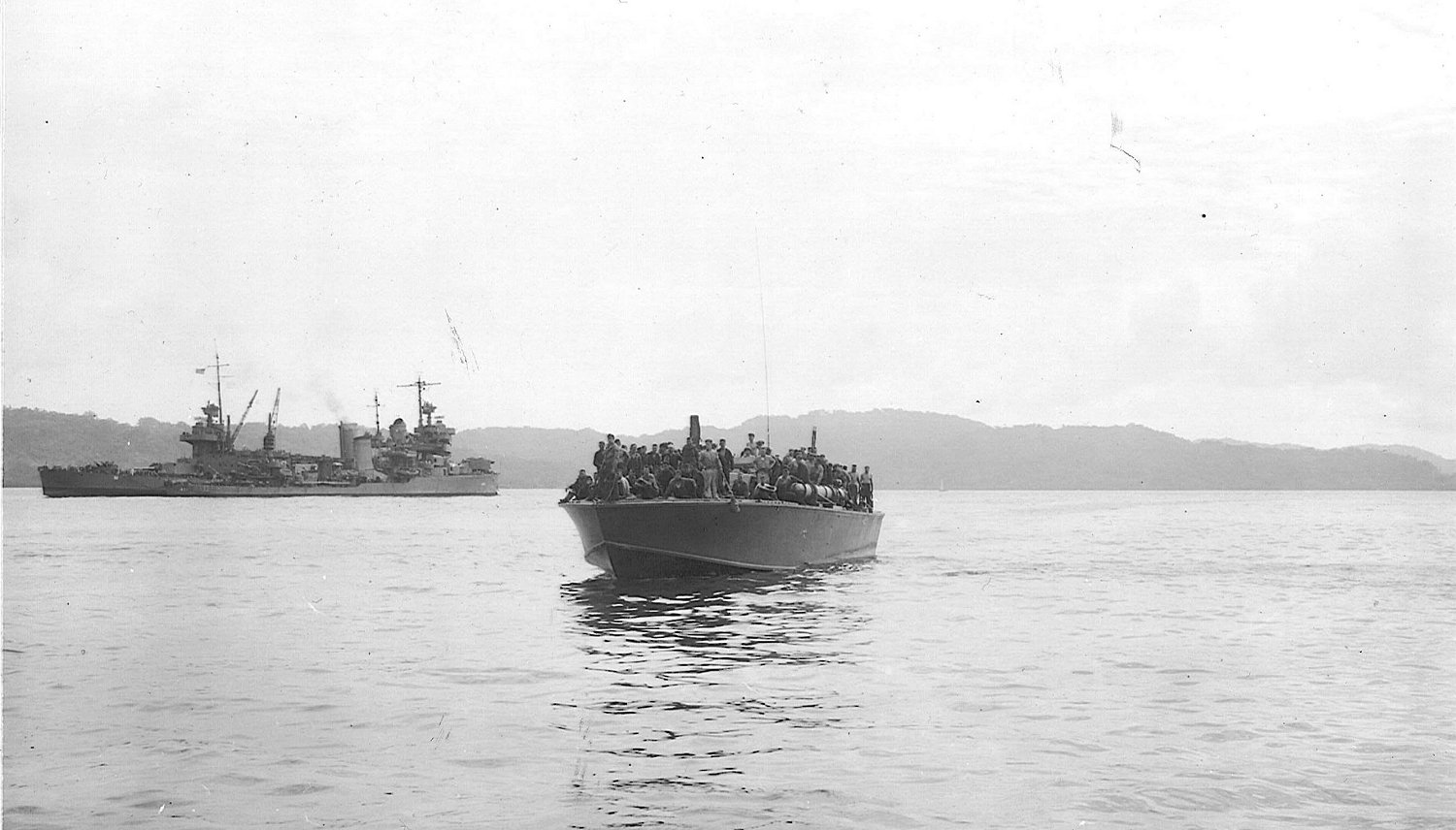 The American torpedo boat PT-109 entering Tulagi carrying 94 survivors from the sunken heavy cruiser USS Northampton (CA-26) The previous night, during the battle of Tassafaronga, Northampton was hit by two torpedoes from the Japanese destroyers Kagerō and Makinami which sank her over 2 hours and 16 minutes. In the background, the crippled heavy cruiser USS New Orleans (CA-32) is seen in the background, having been hit by a torpedo from the destroyer Takanami which sheared off her bow and turret 1.